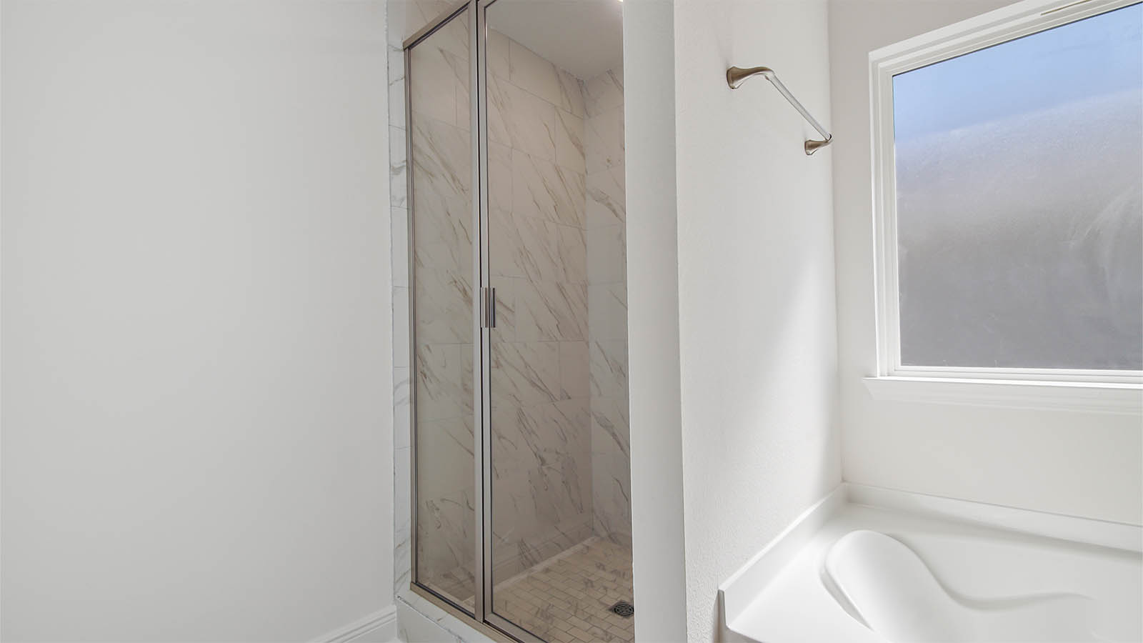 Primary bathroom shower with tile and tub.