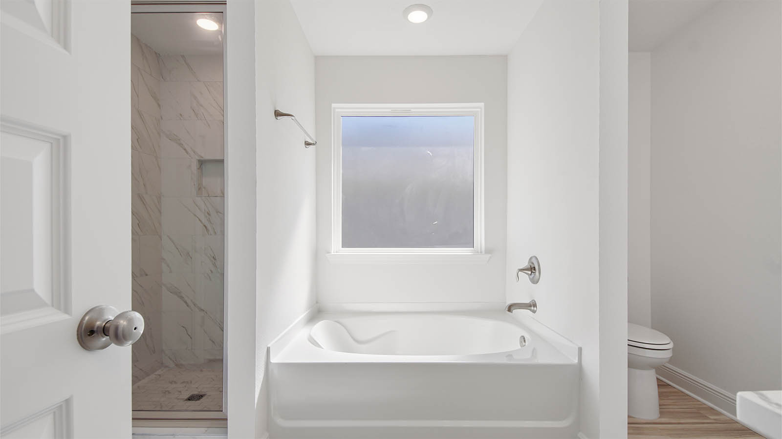 Primary bathroom tub and window.