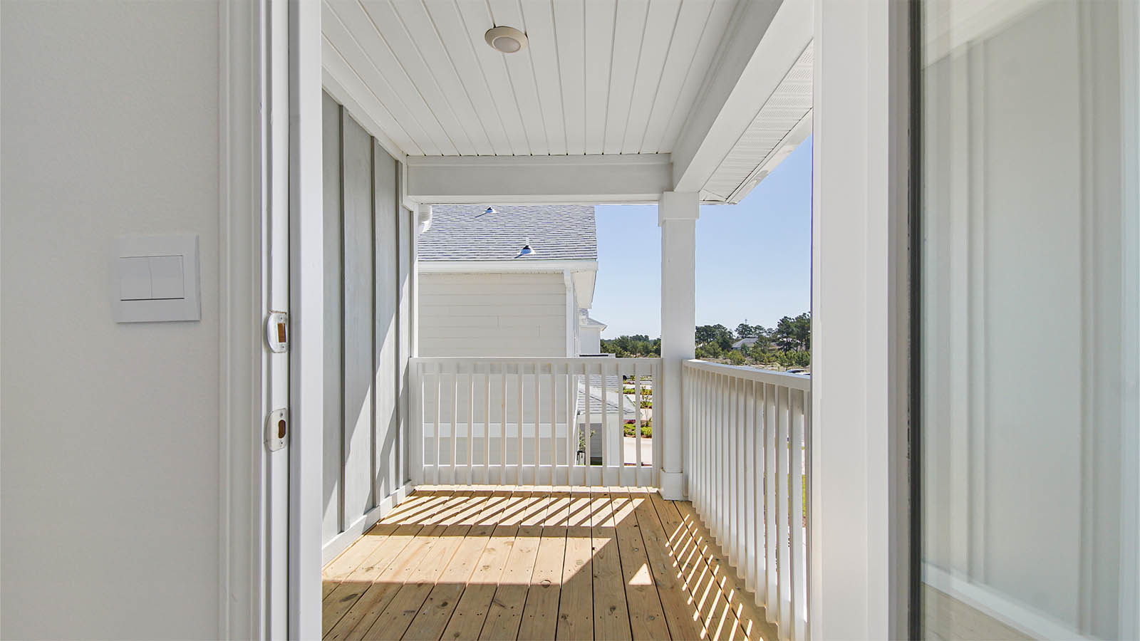 Balcony with wood flooring and ceiling light.