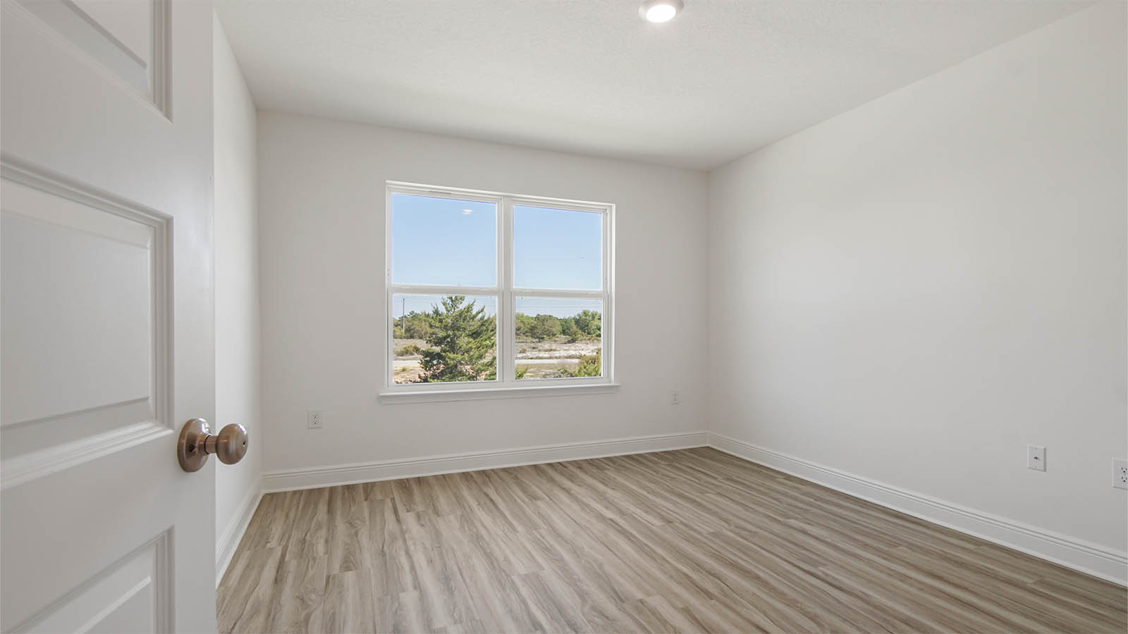 Bedroom with EVP flooring and window.