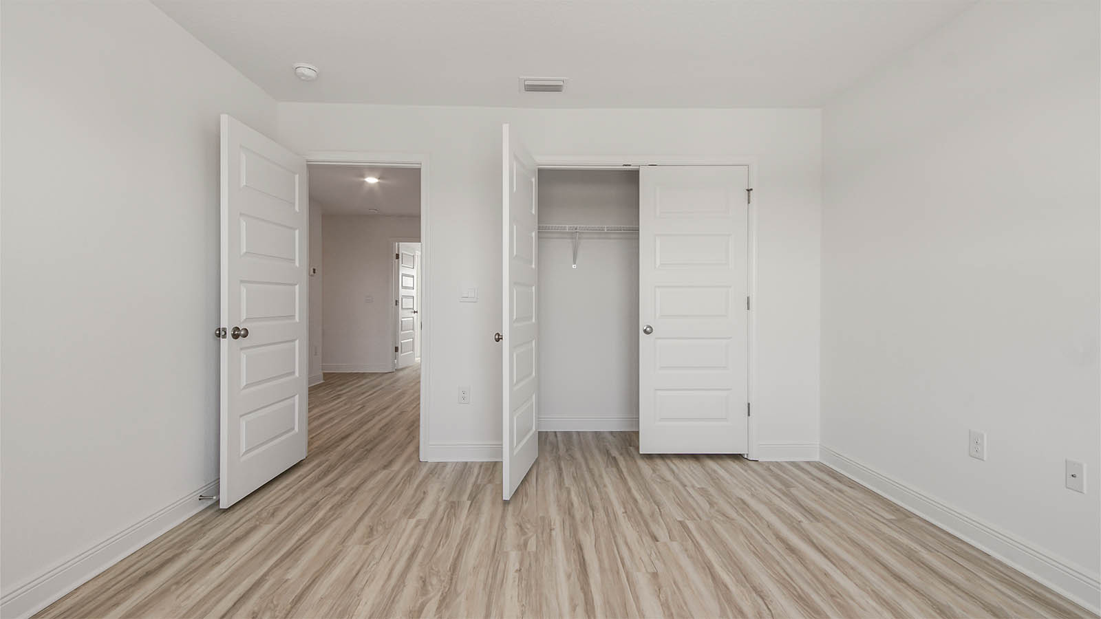 Bedroom with EVP flooring and closet.
