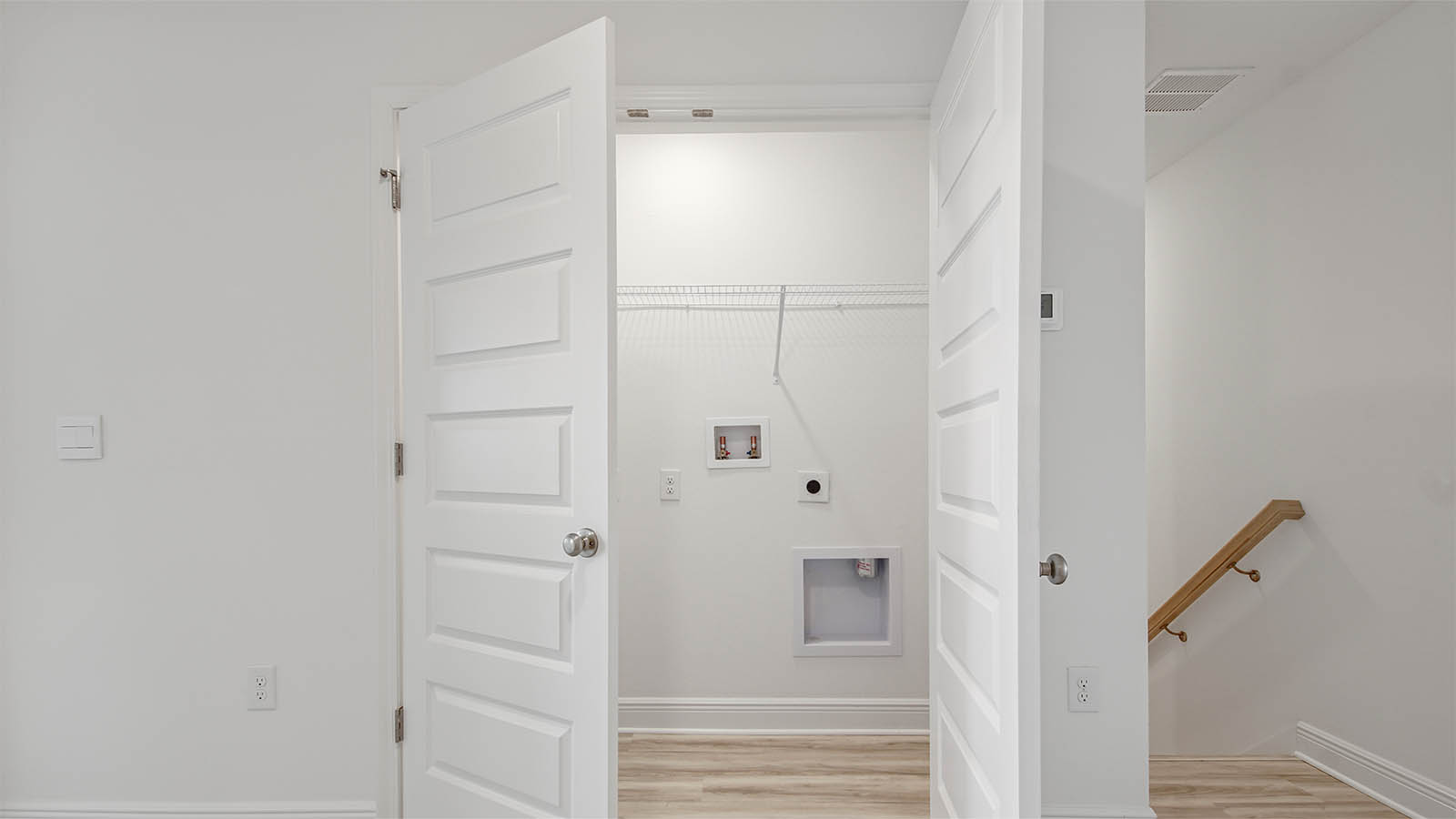 Upstairs laundry room with EVP flooring and ventilated shelving.
