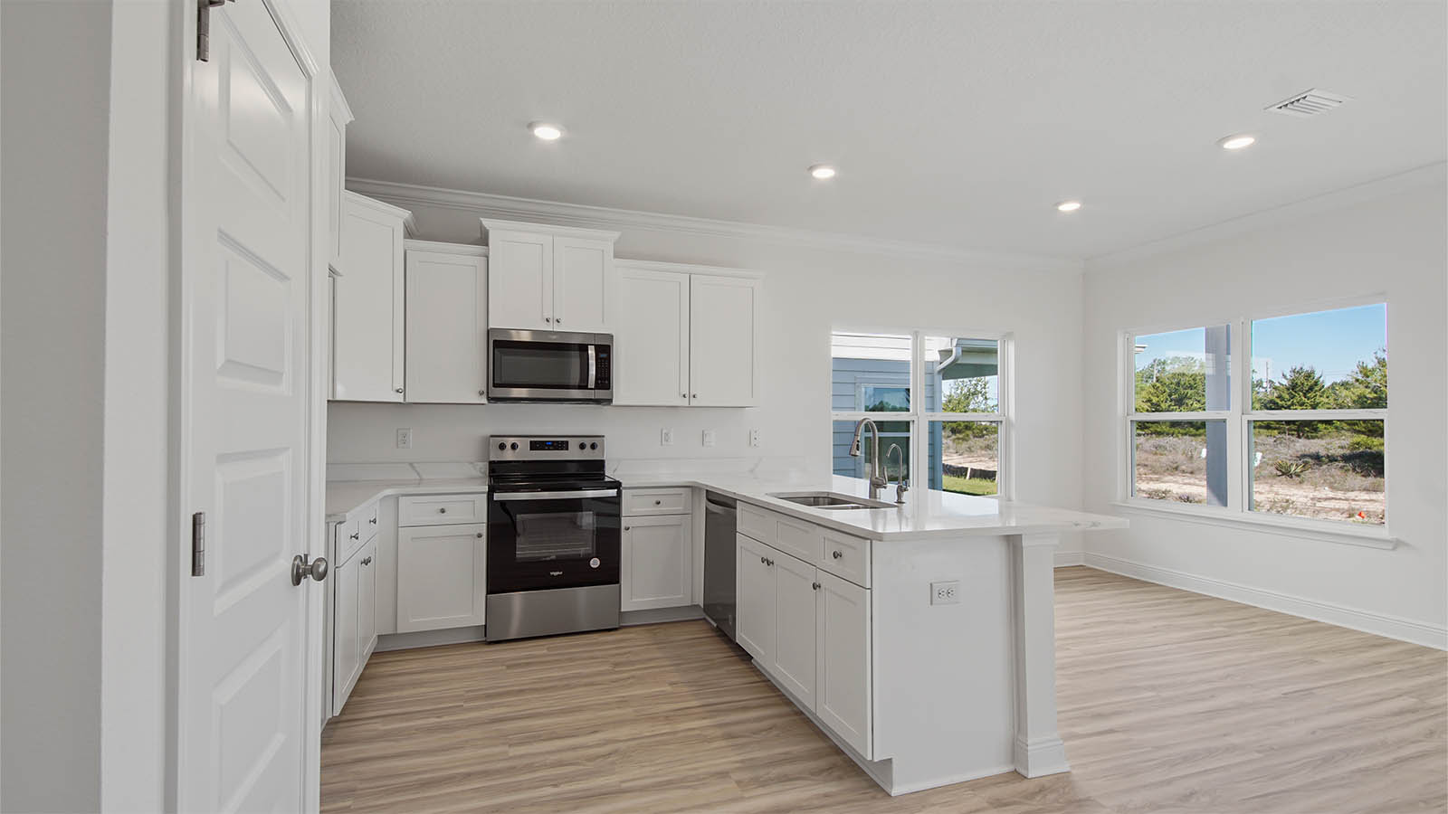 Kitchen with quartz countertops and white cabinets and stainless steel appliances.