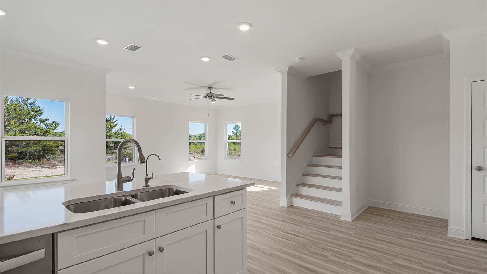 Kitchen with quartz countertops and white cabinets and stainless steel appliances and dining area.
