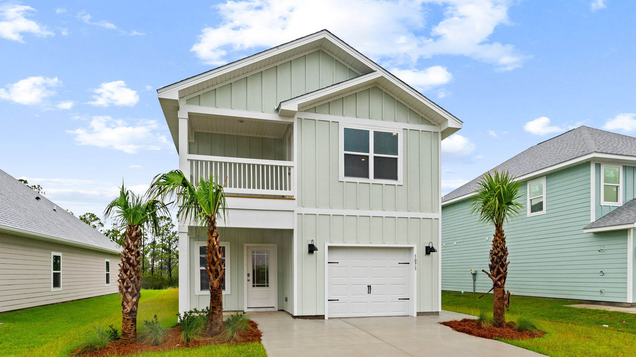 Monroe floor plan at WindMark Beach with Hardie siding and covered front porch and balcony and 1 car garage.