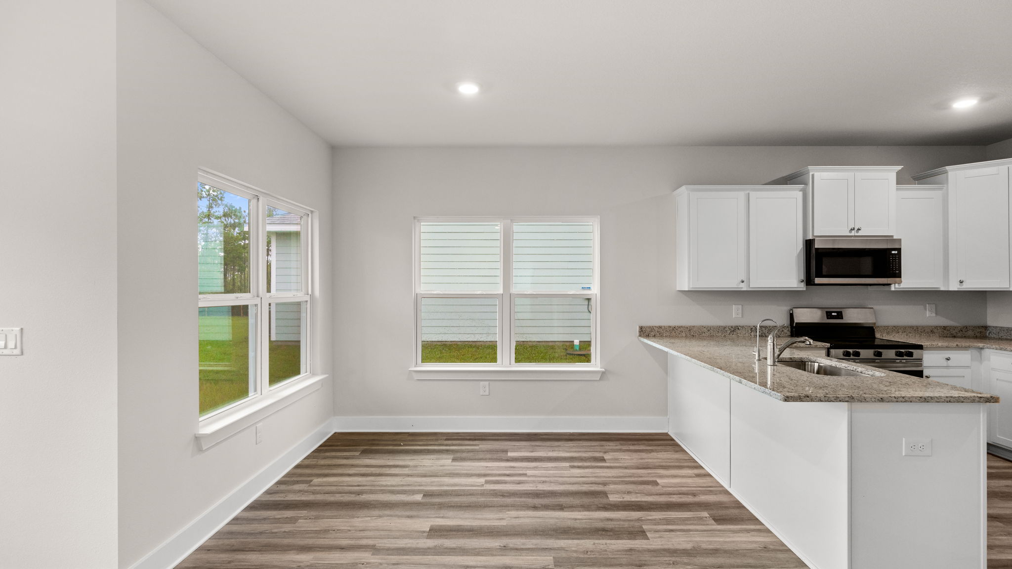 Dining area next to kitchen with windows.