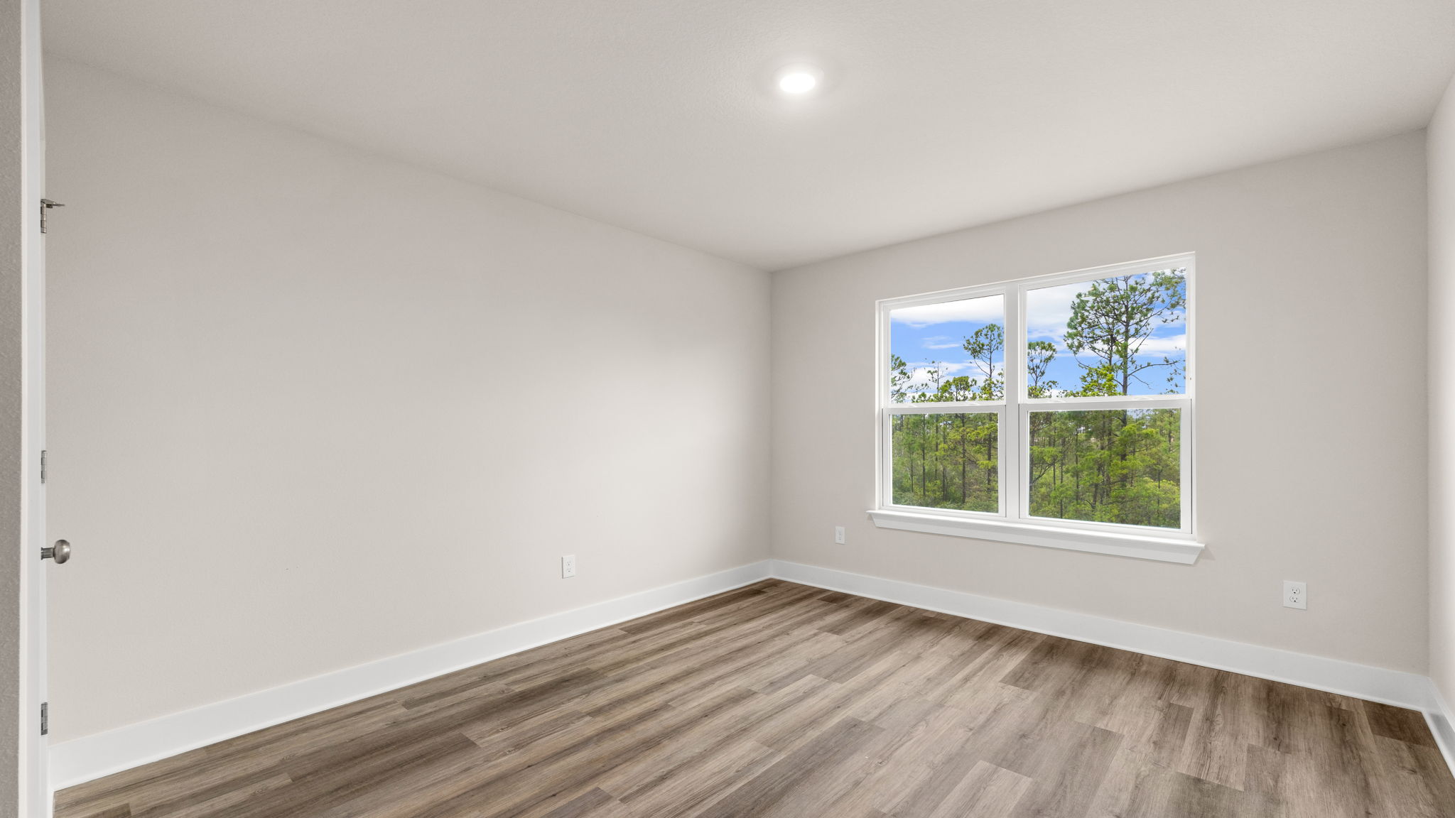 Bedroom with EVP flooring and window.