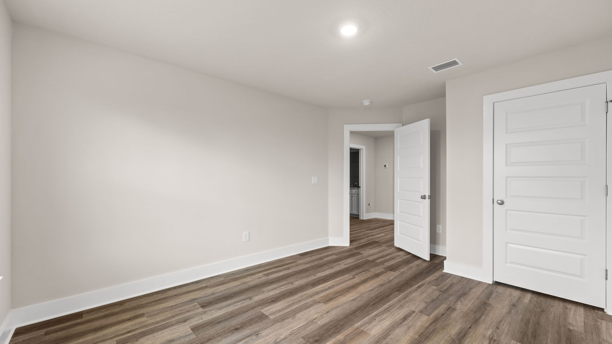 Bedroom with EVP flooring and closet.