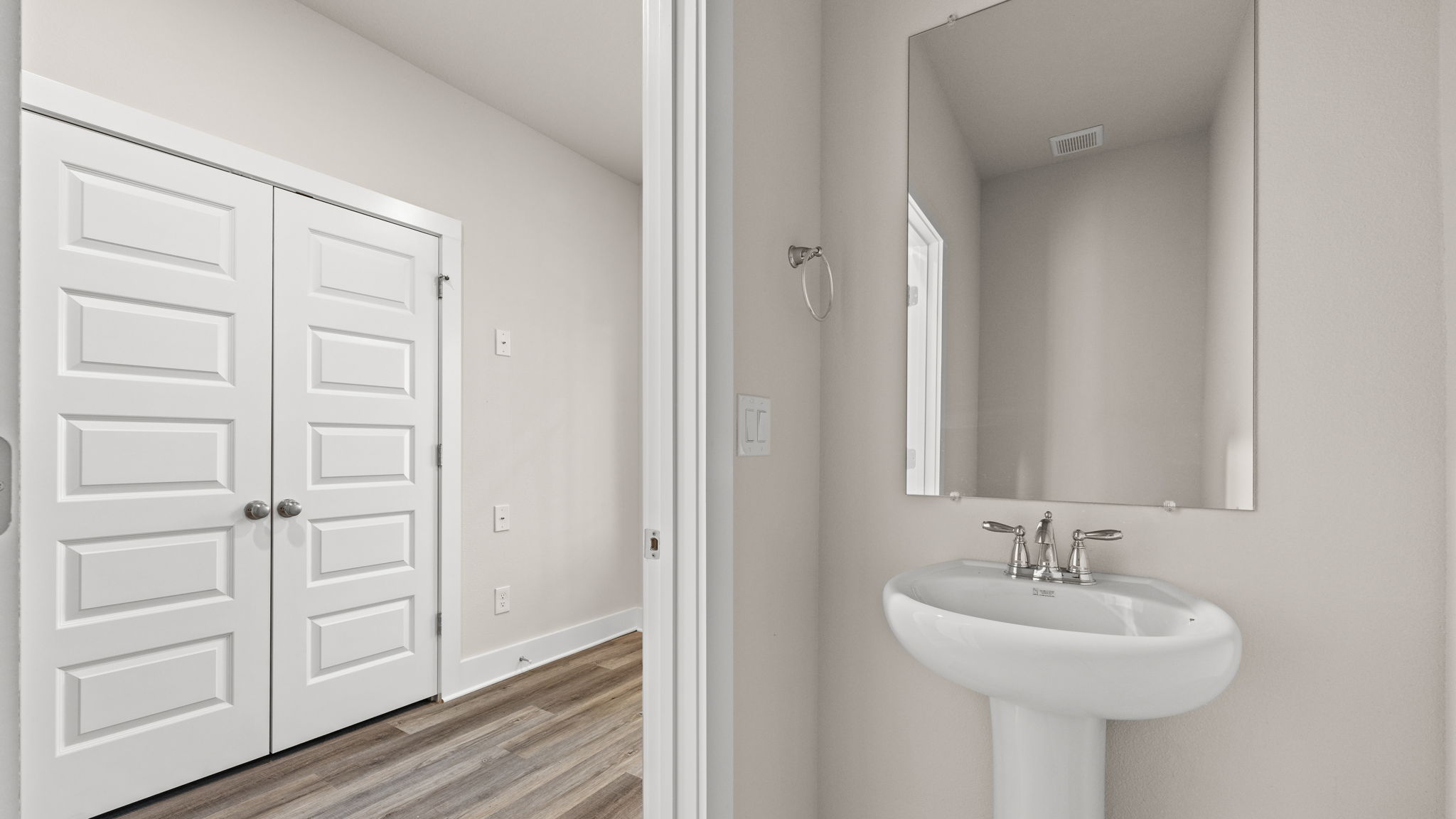 Half bathroom in hallway across from laundry room.