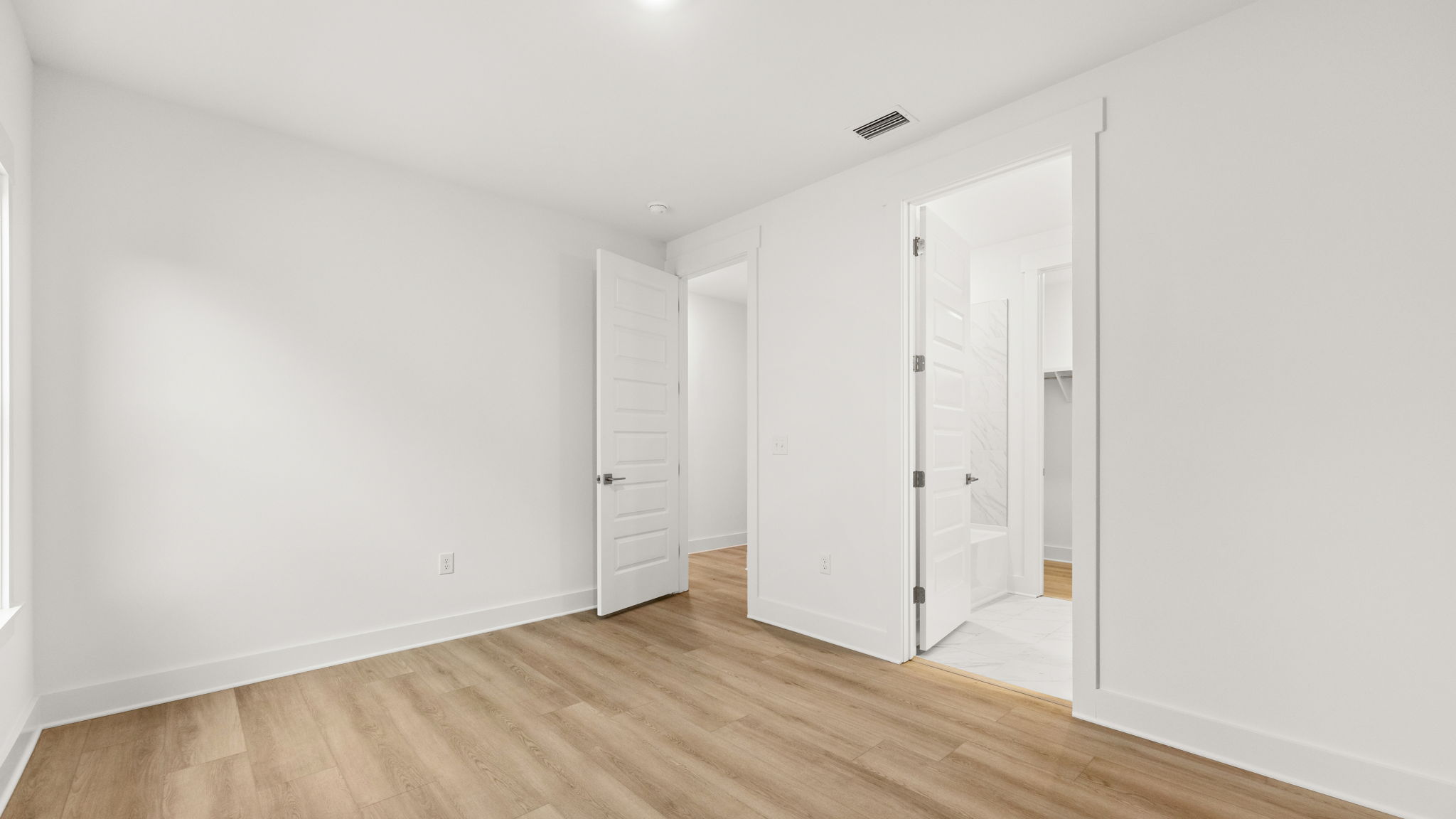Bedroom with EVP flooring and bathroom entrance.