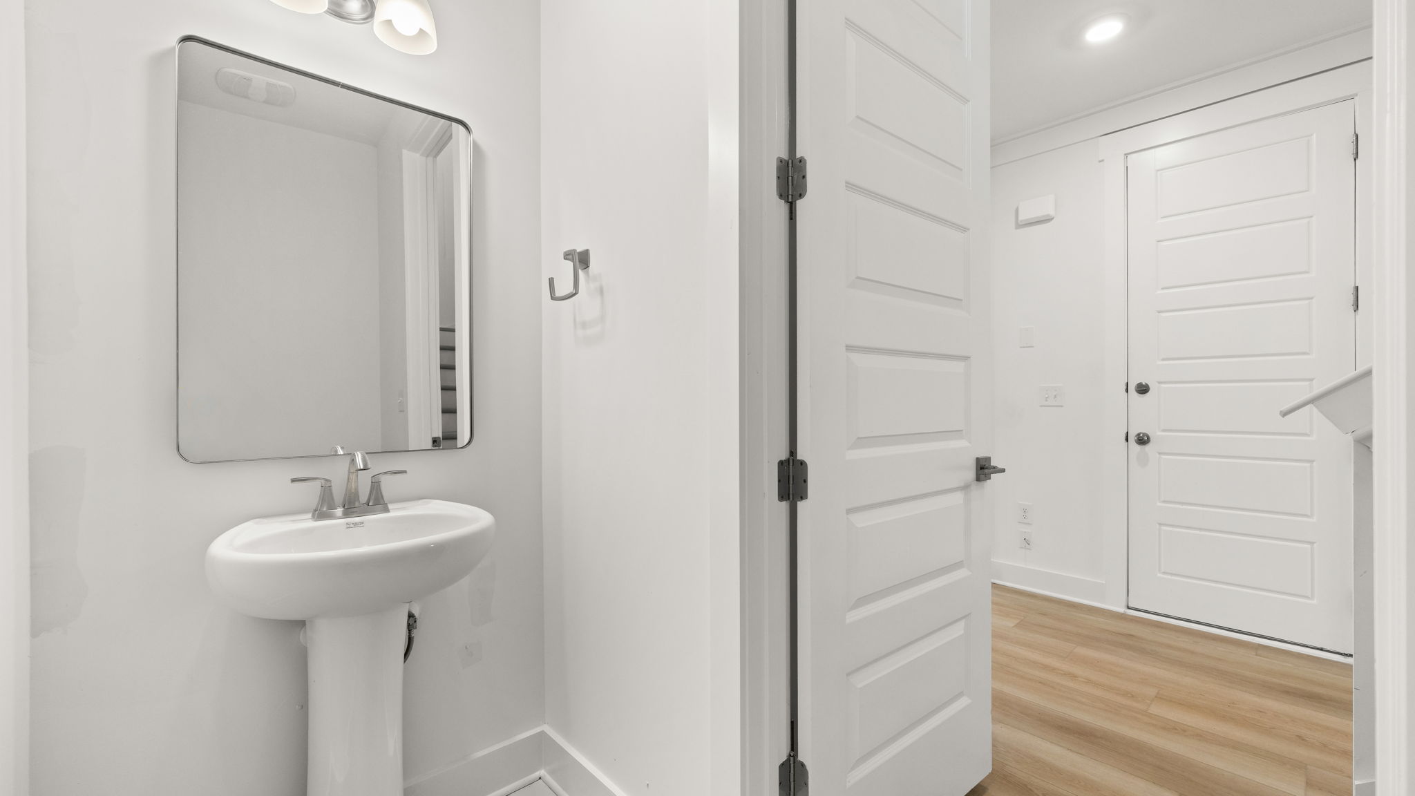 Half bathroom next to sink and garage door.