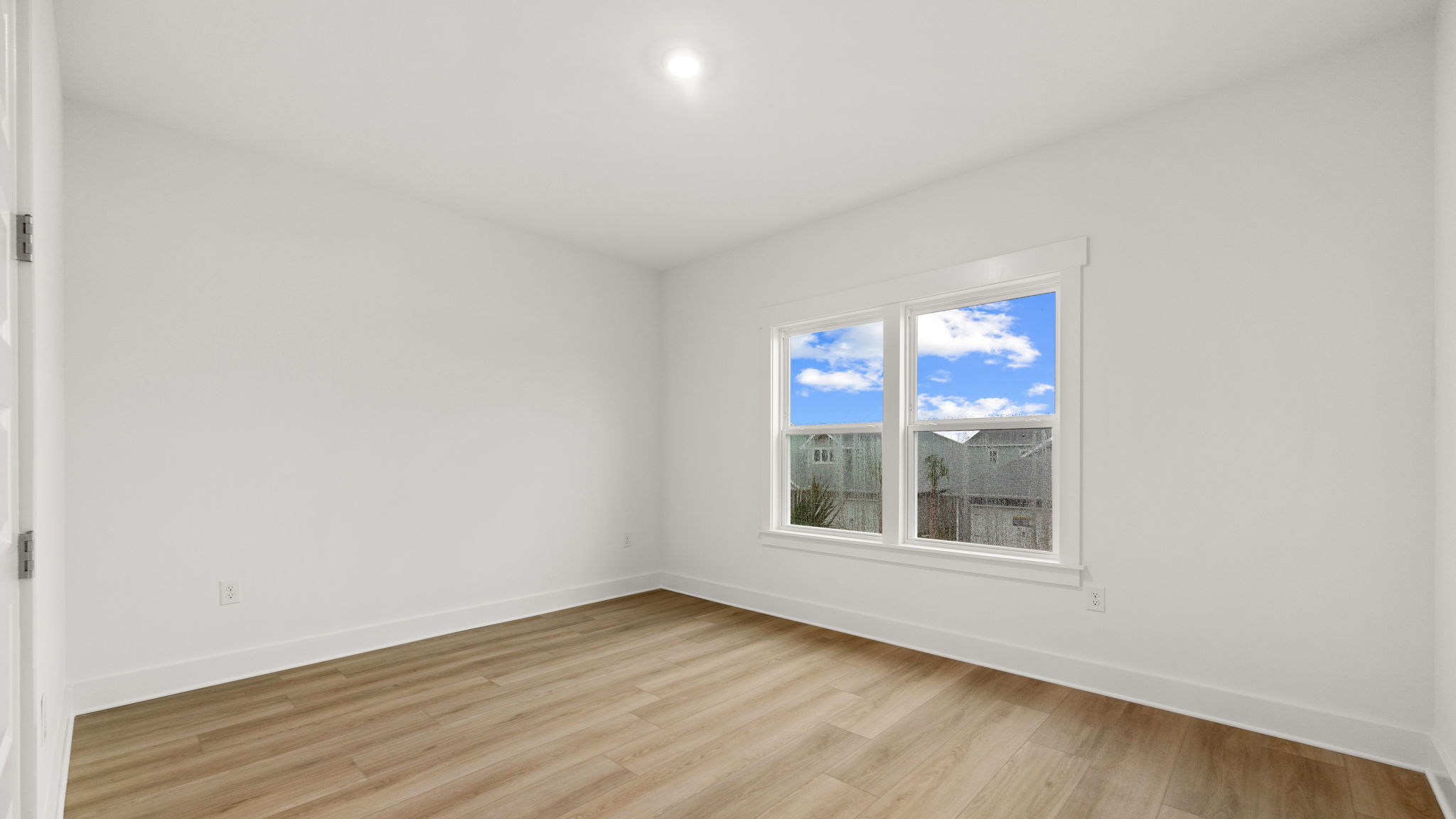 Bedroom with EVP flooring and windows.