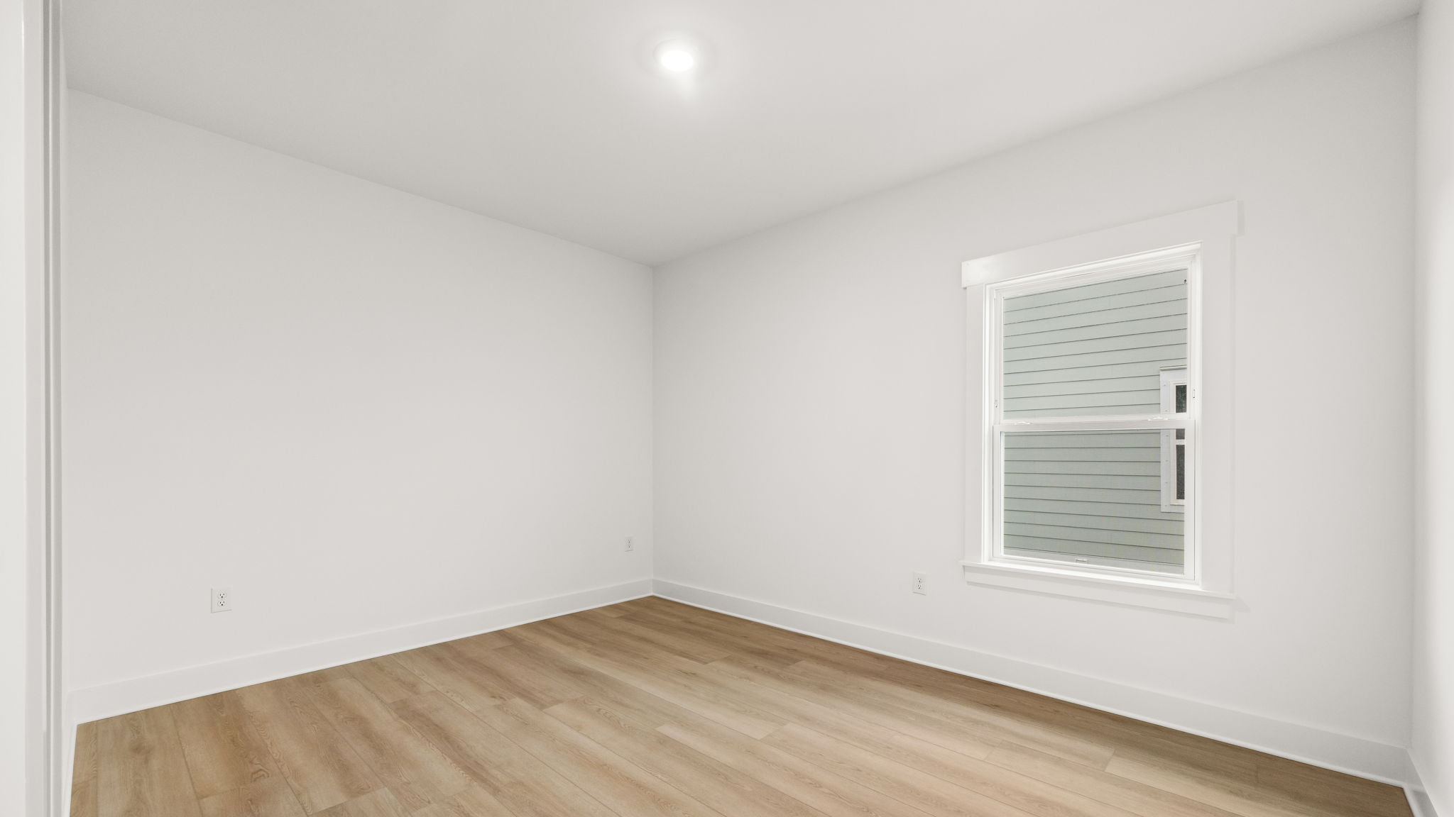 Bedroom with EVP flooring and window.
