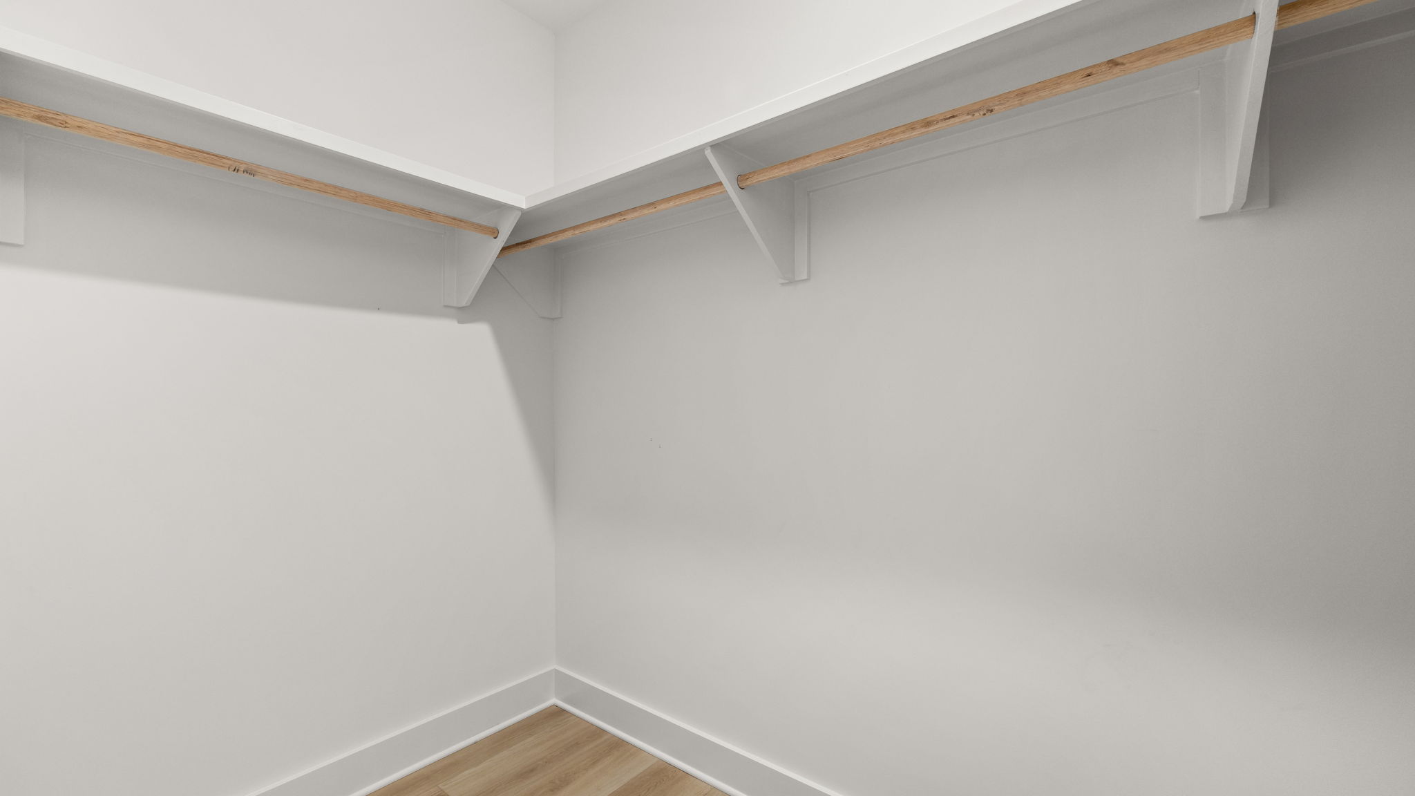 Closet with EVP flooring and wood shelving.