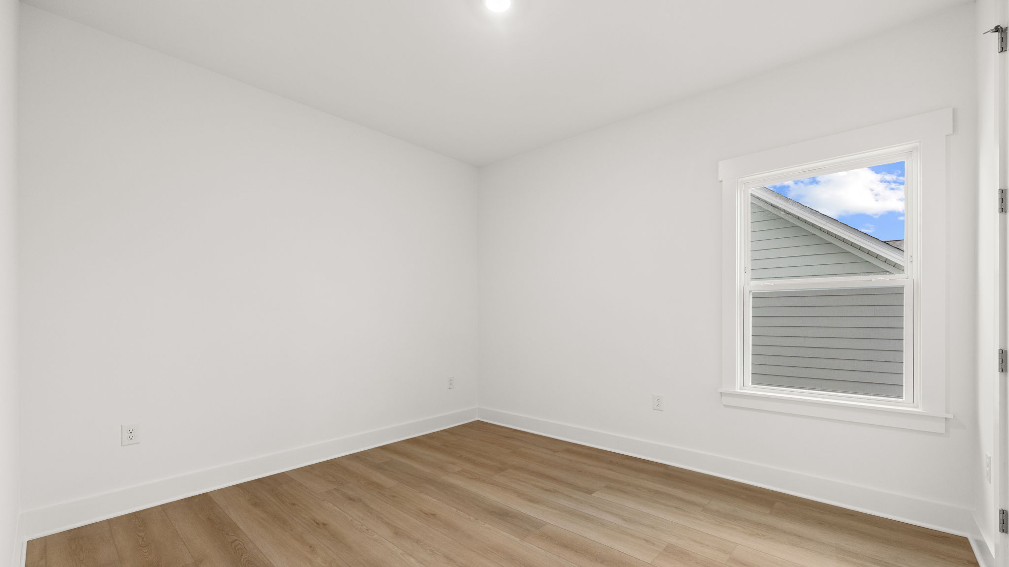 Bedroom with EVP flooring and window.