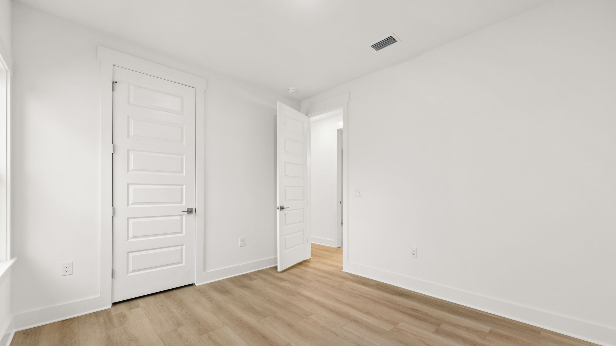 Bedroom with EVP flooring and closet.