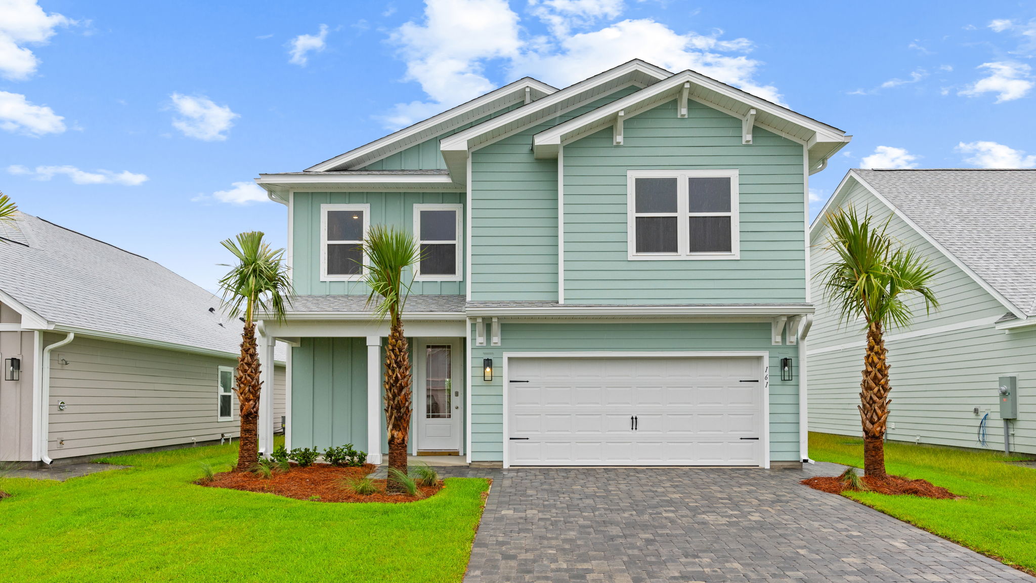 Brayden plan at WindMark Beach with Hardie siding and two car garage and paver driveway.