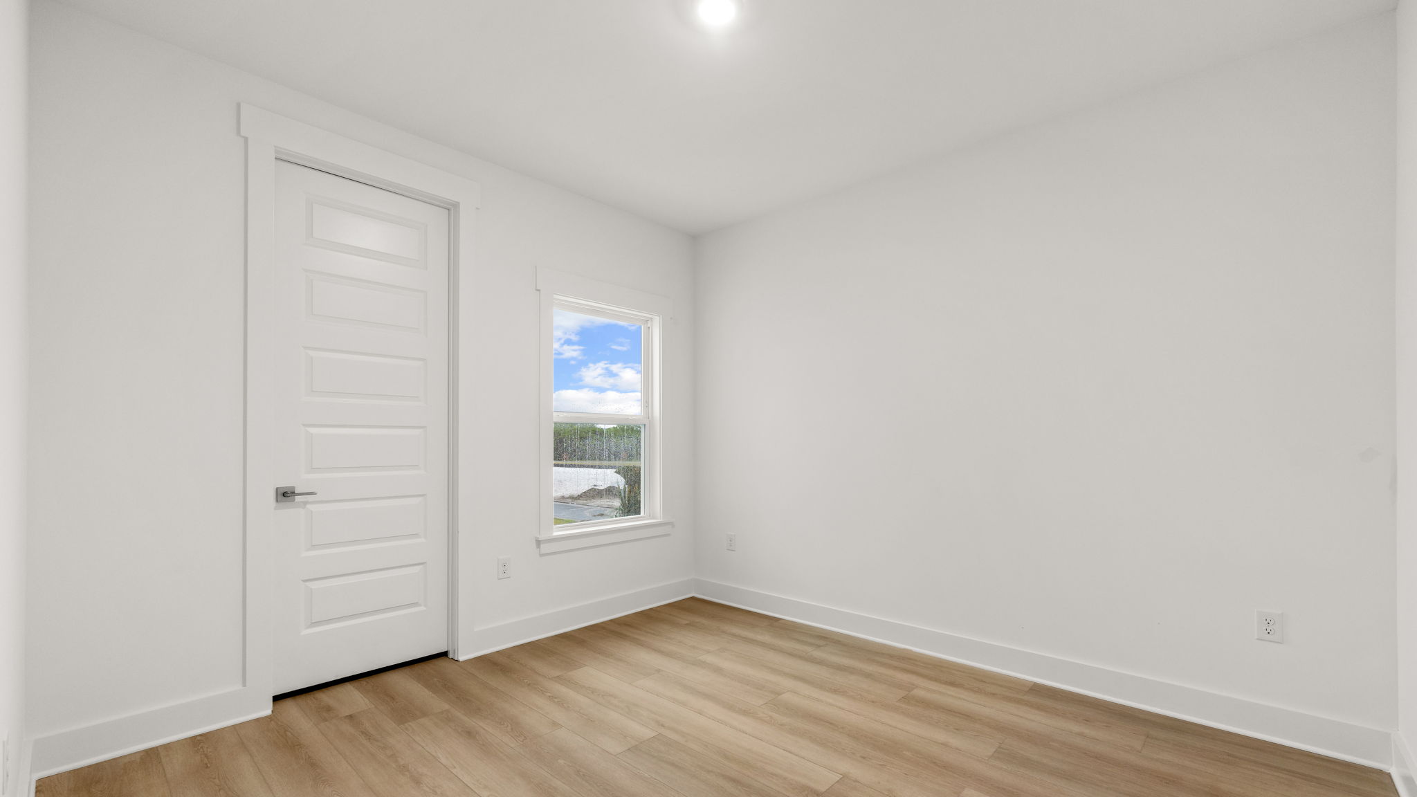 Bedroom with EVP flooring and window and closet.