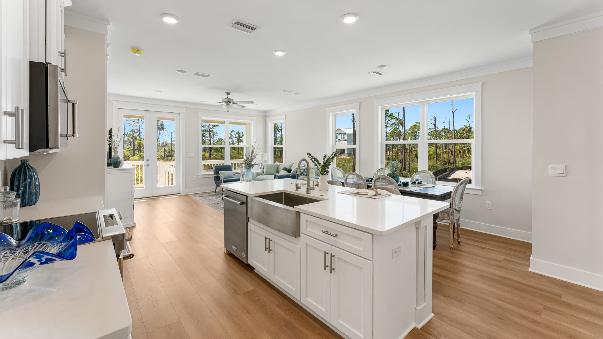 Open kitchen with island with quartz countertops and stainless-steel appliances looking into living room.