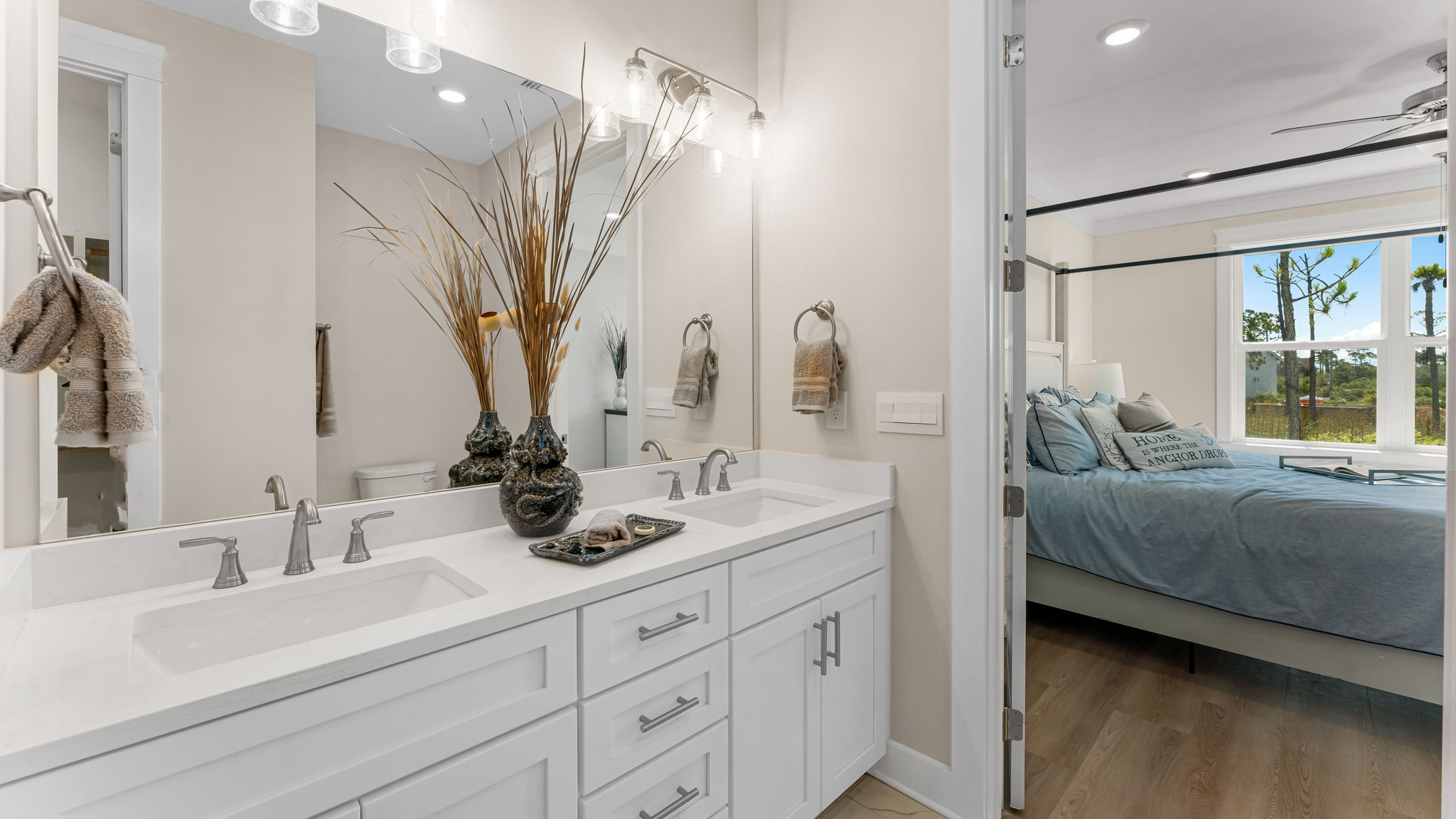 Primary bathroom with double vanity quartz countertops with white cabinets.