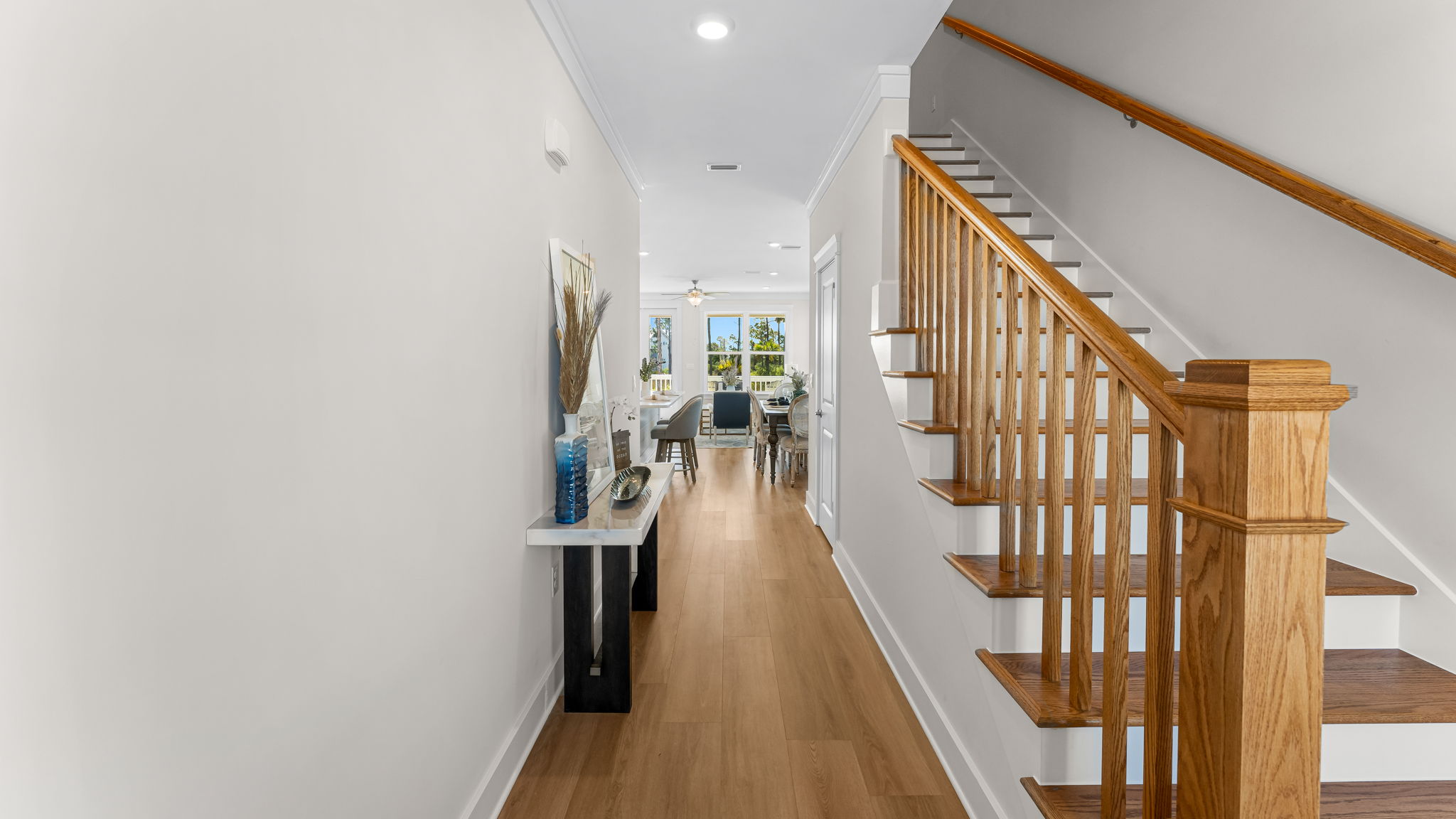 Front entrance hallway with EVP flooring next to wooden stairs.