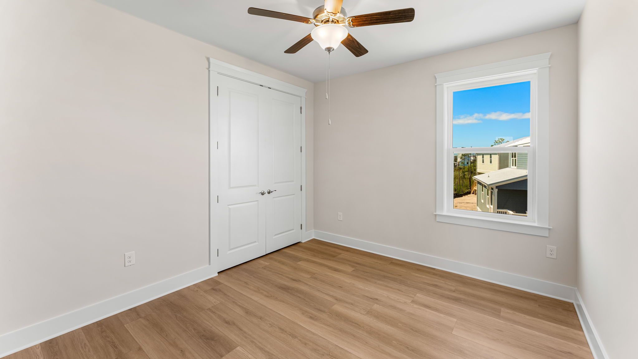 Bedroom with EVP flooring and closet and ceiling fan and window.