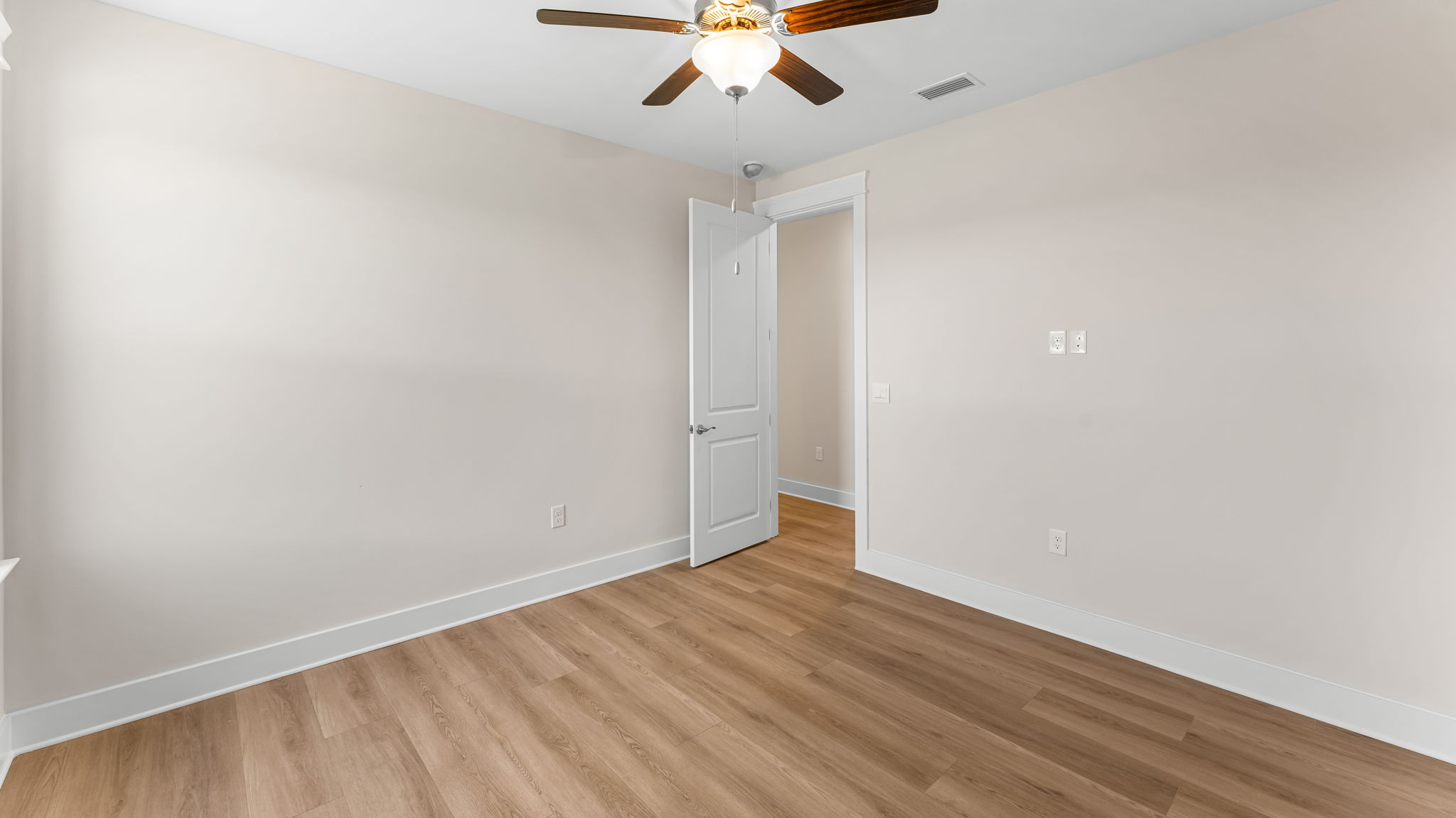 Bedroom with EVP flooring and ceiling fan.