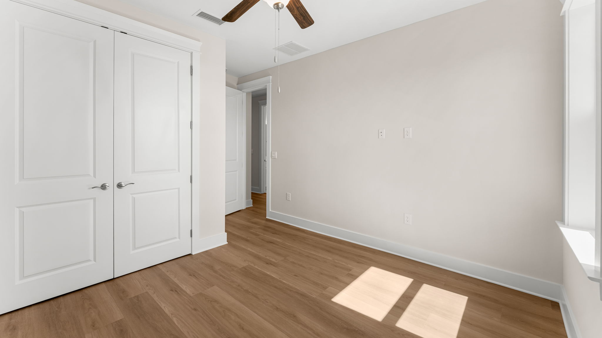 Bedroom with EVP flooring and closet and ceiling fan.