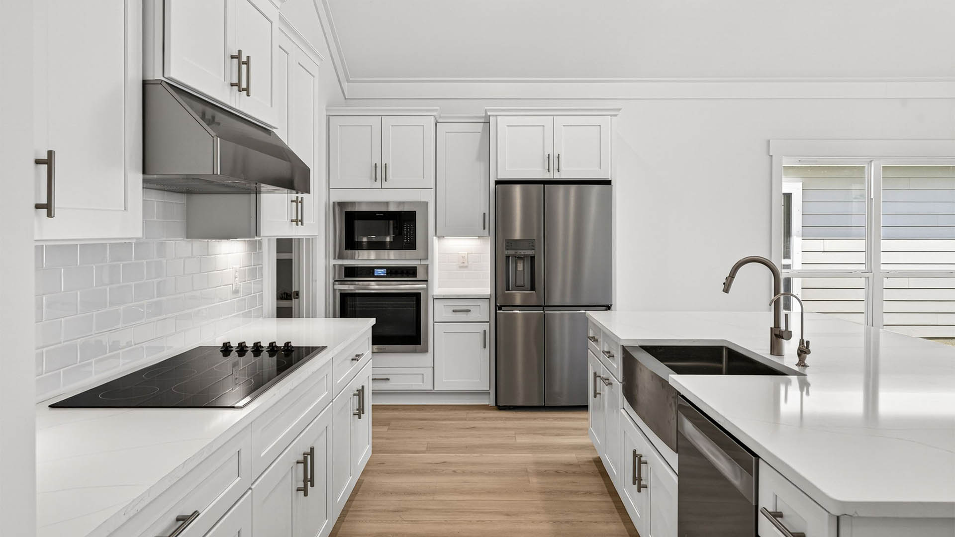 Kitchen with quartz countertops and backsplash and stainless-steel appliances and island.