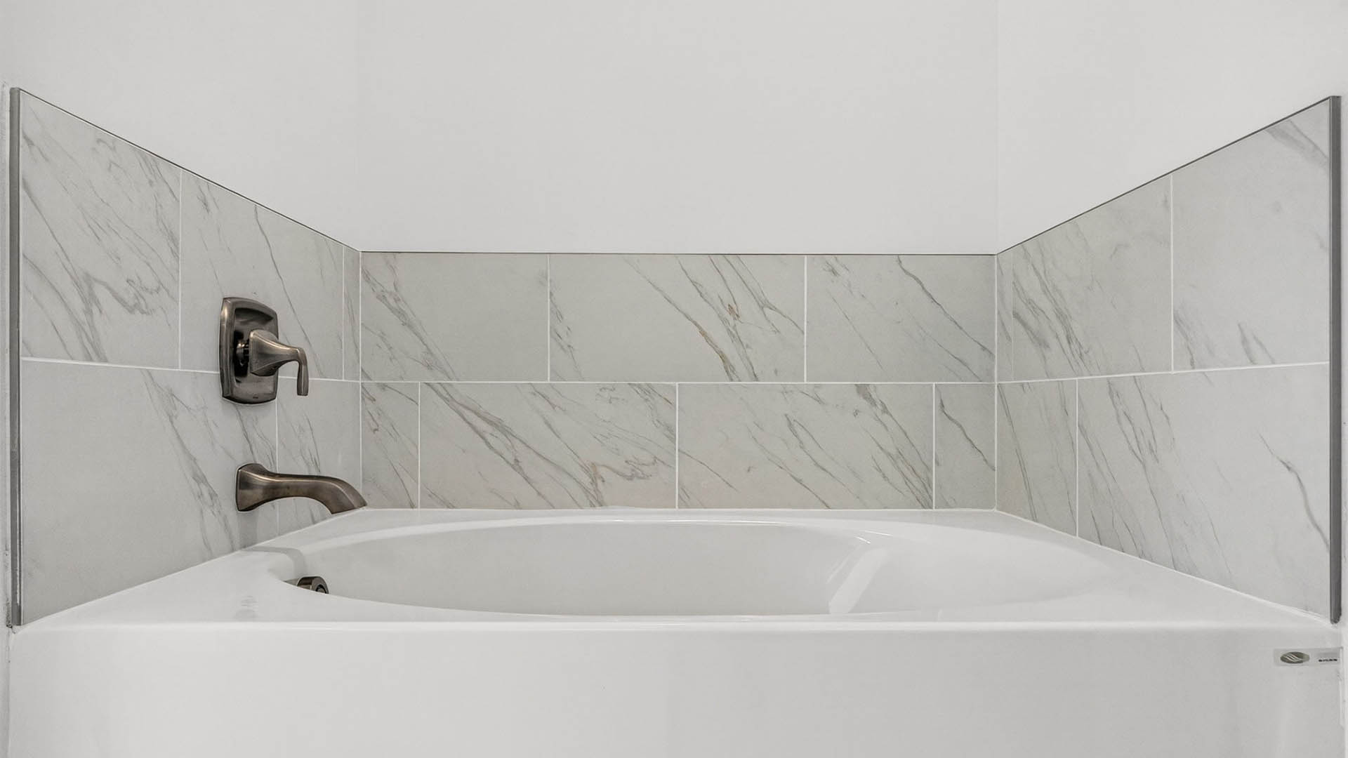 Tub with tile backsplash.