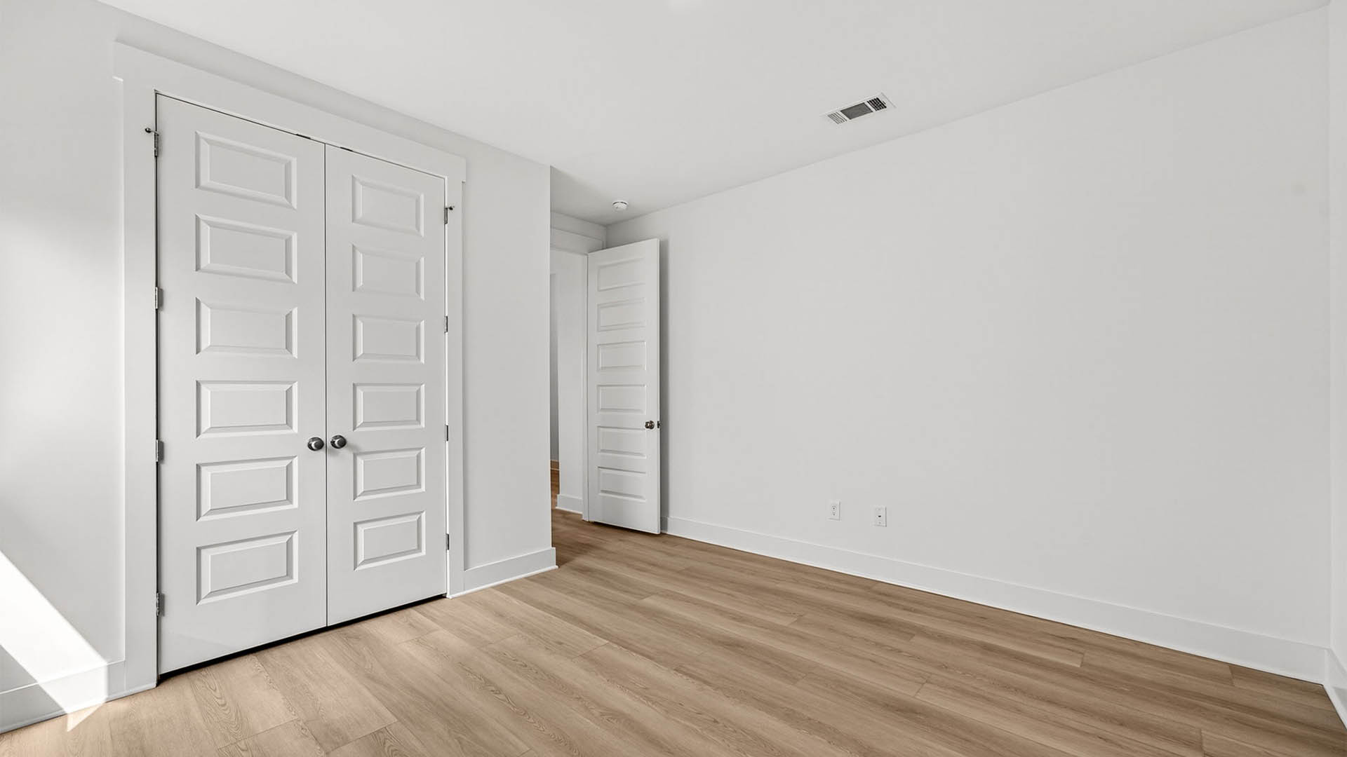 Bedroom with EVP flooring and closet.