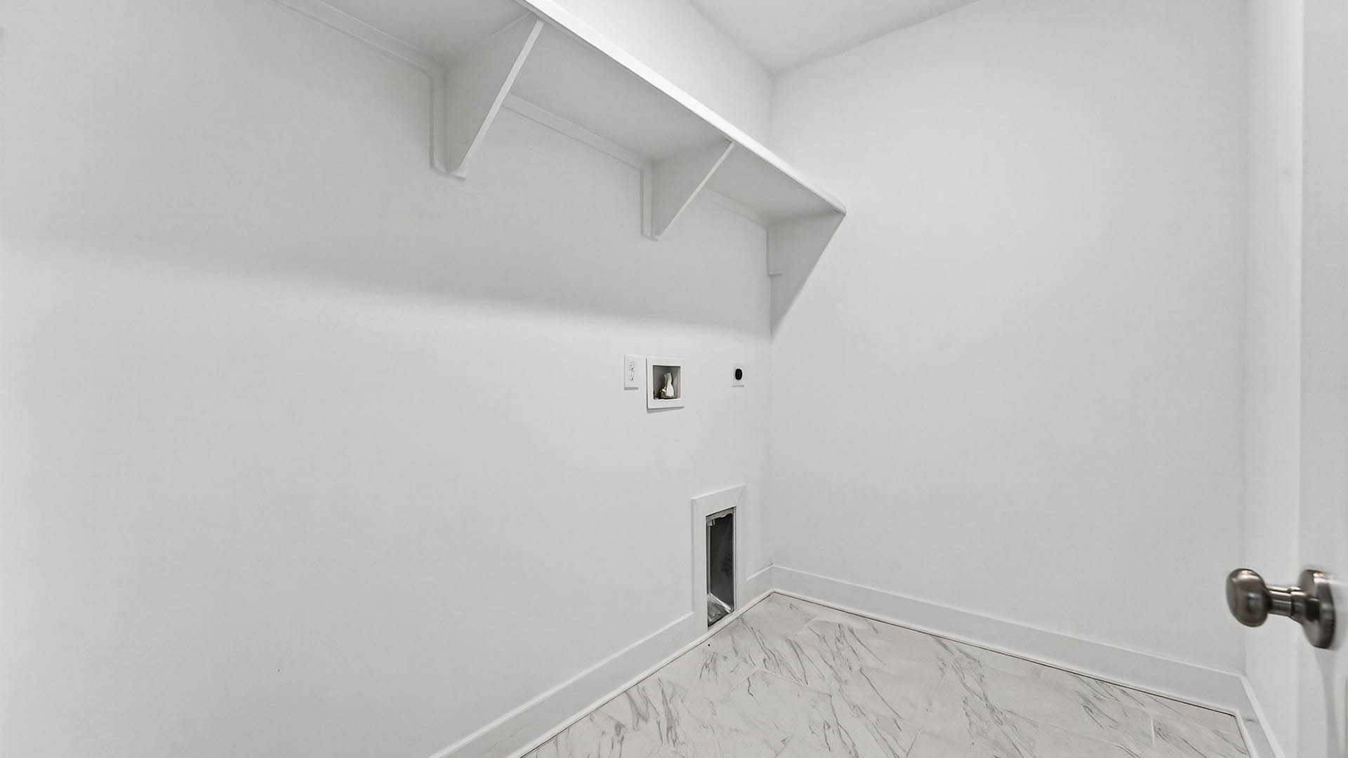 Laundry room with wooden shelves and tile flooring.