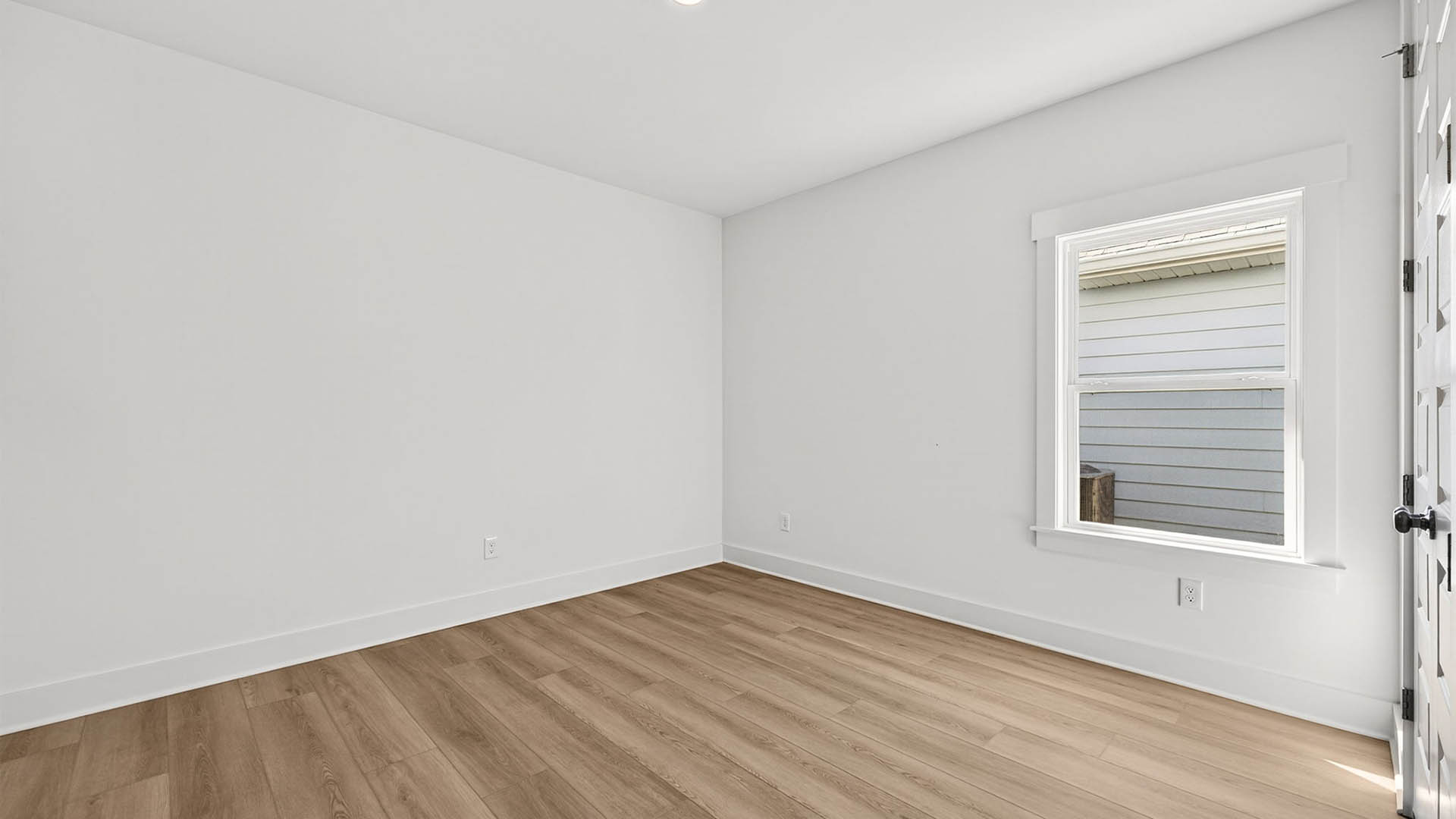 Bedroom with EVP flooring and window and closet.