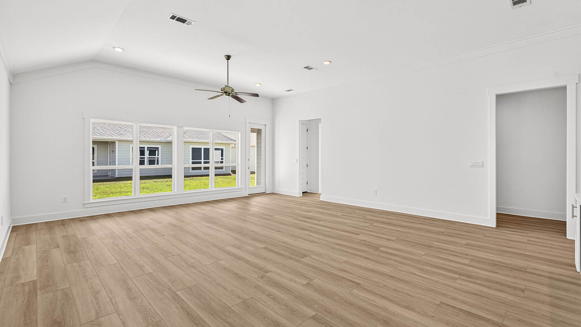 Open living room with ceiling fan and EVP flooring.