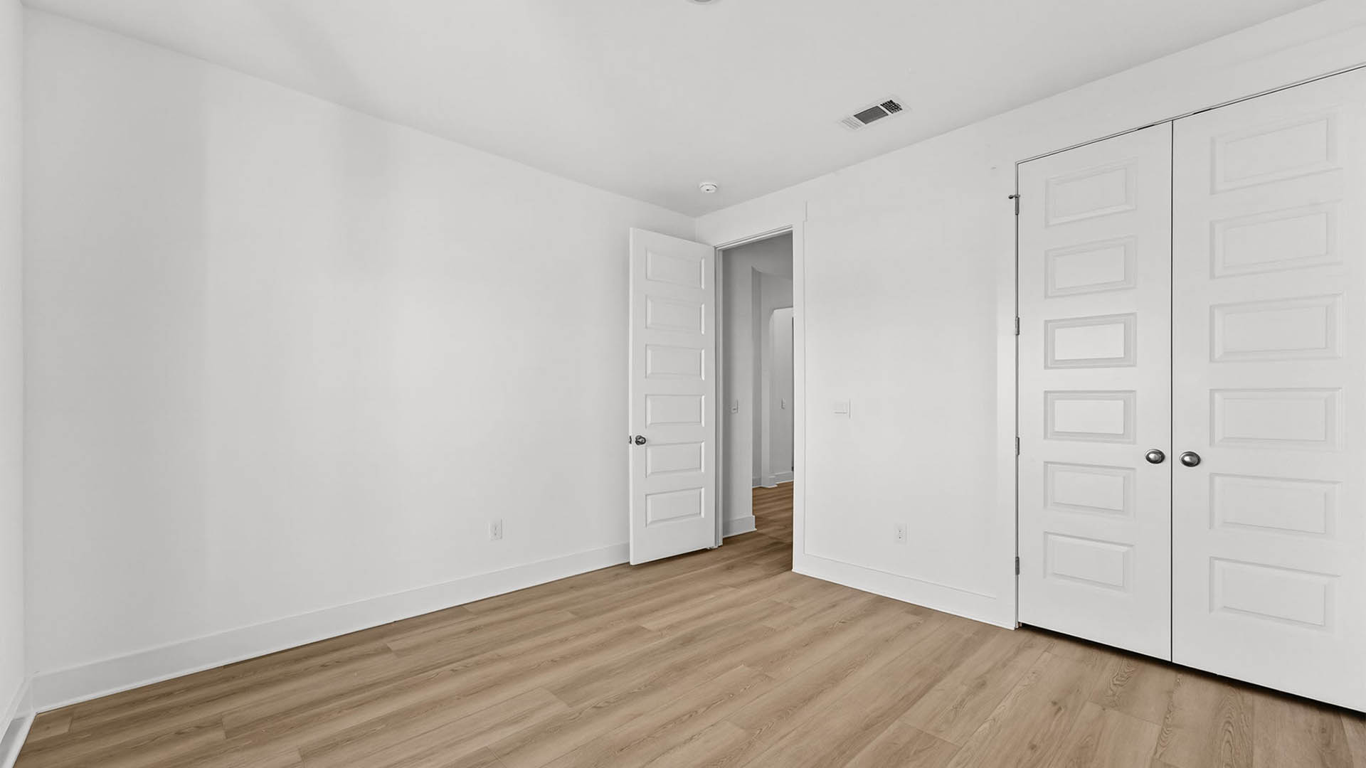 Bedroom with EVP flooring and closet.