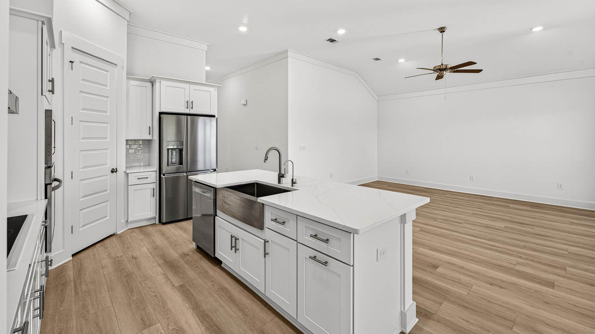 Kitchen with quartz countertops and backsplash and stainless-steel appliances and island.