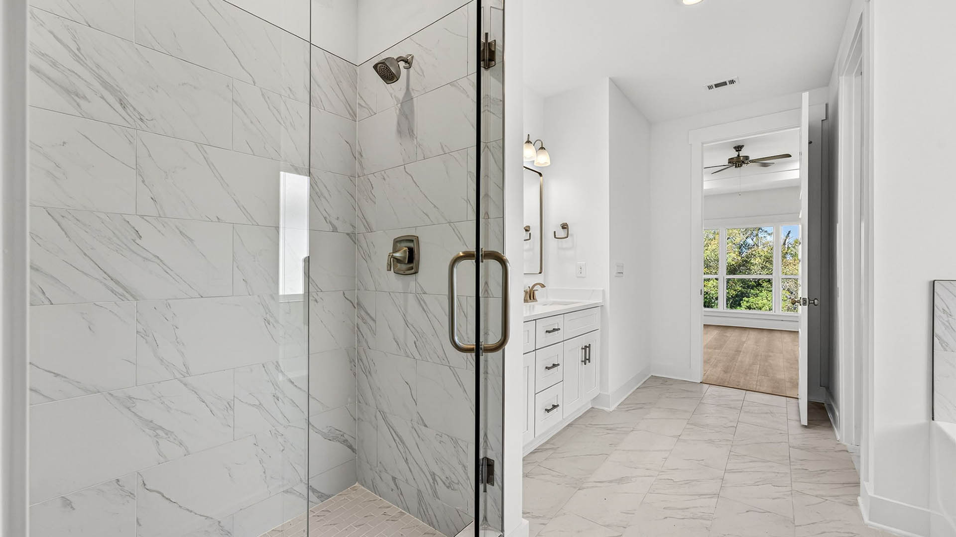 Tile shower with glass door and bathroom with tile floor.