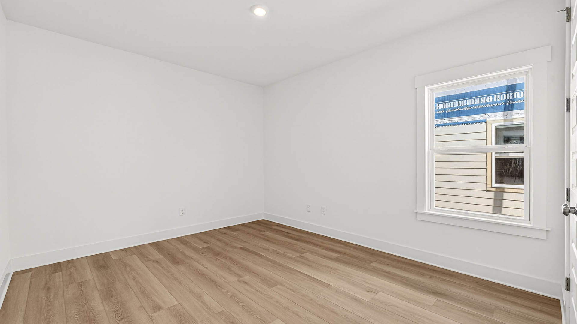 Bedroom with EVP flooring and window and closet.