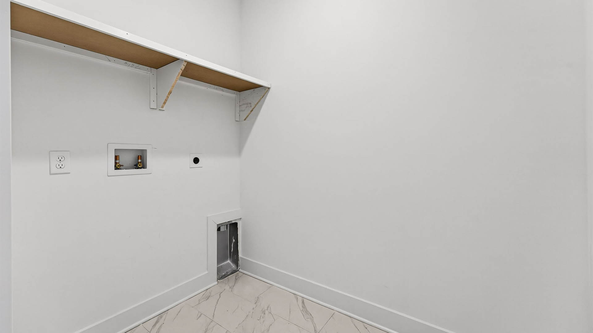 Laundry room with wooden shelves and tile flooring.