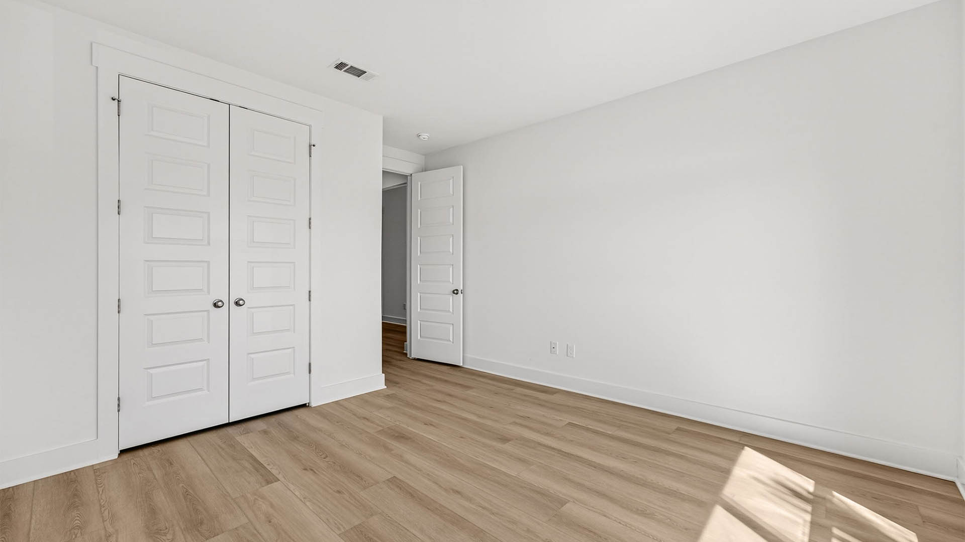 Bedroom with EVP flooring and closet.