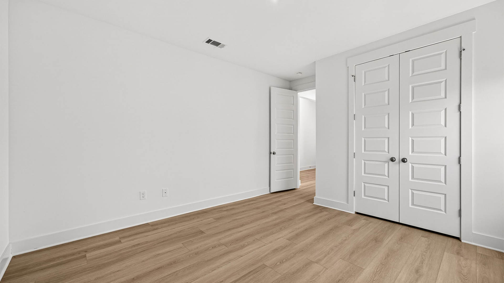 Bedroom with EVP flooring and closet.