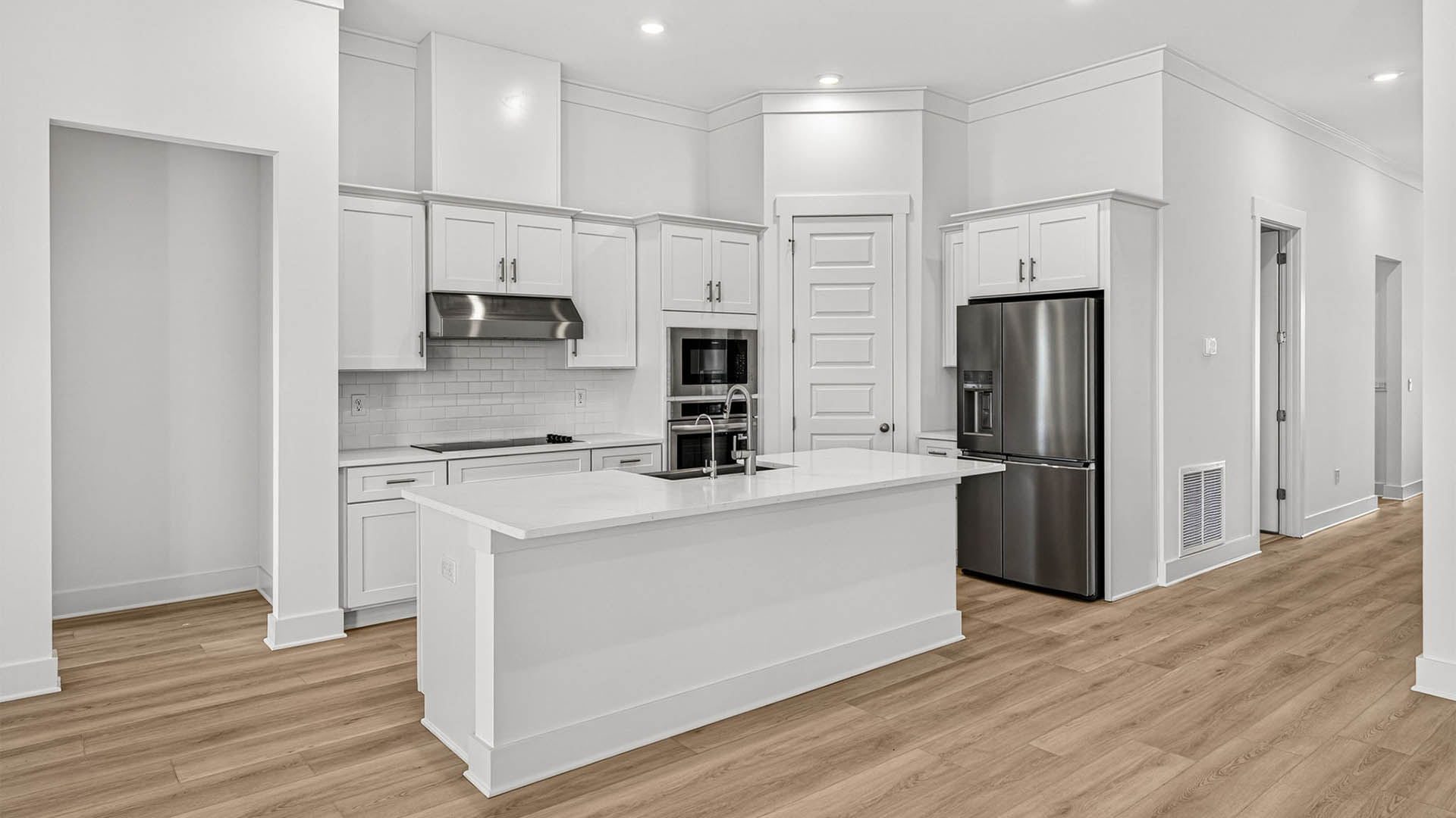 Kitchen with quartz countertops and backsplash and stainless-steel appliances and island.