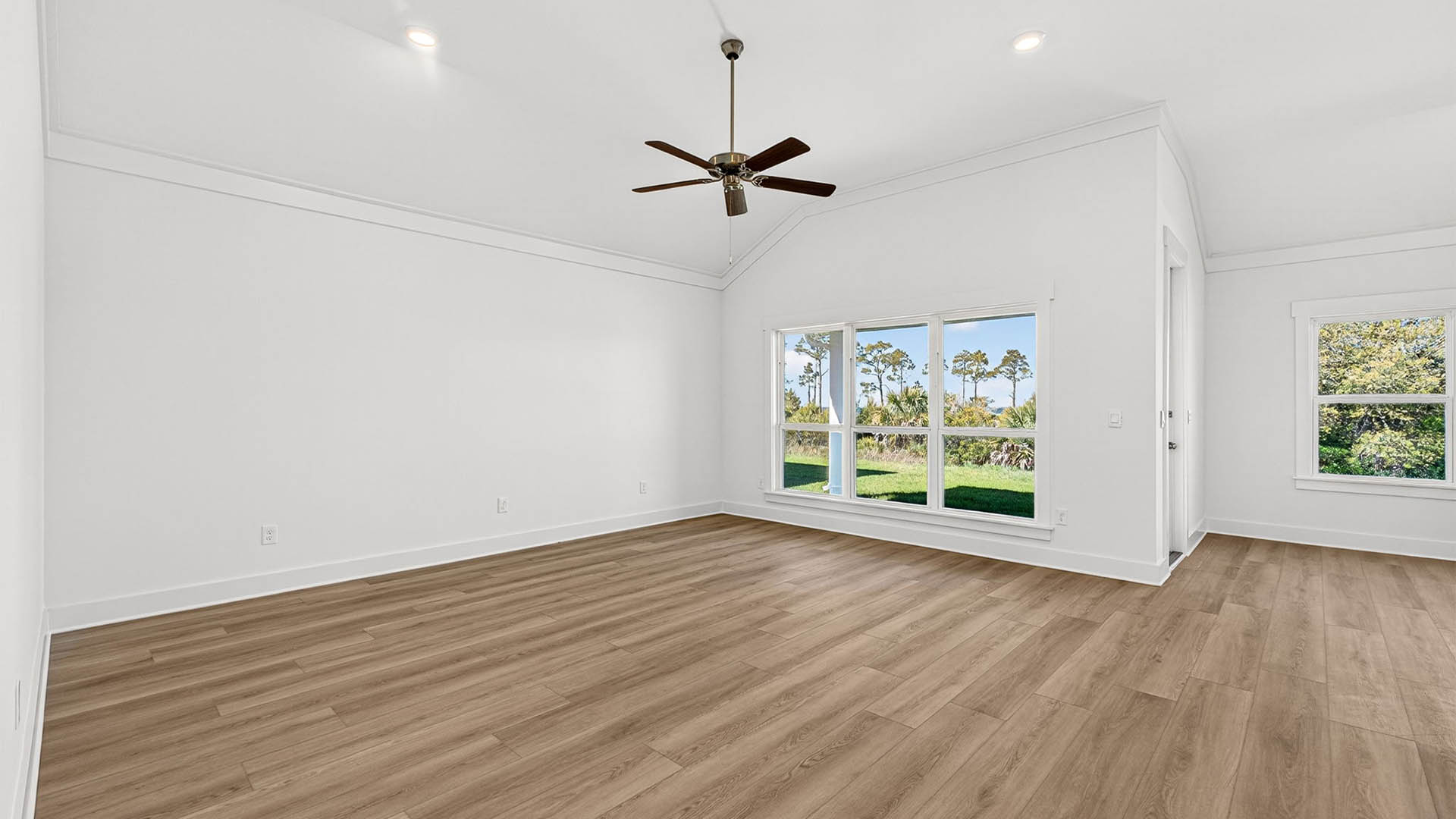 Open living room with ceiling fan and EVP flooring.