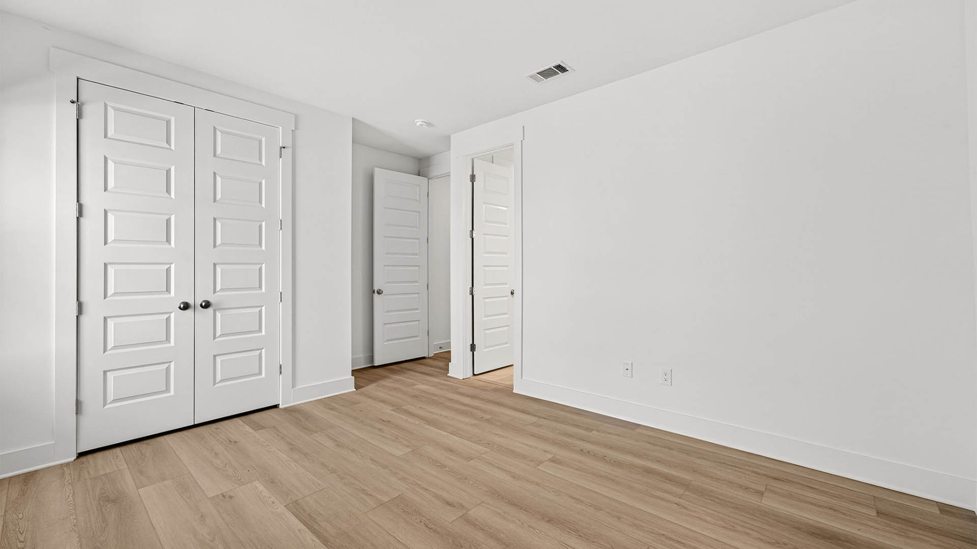 Bedroom with EVP flooring and closet.