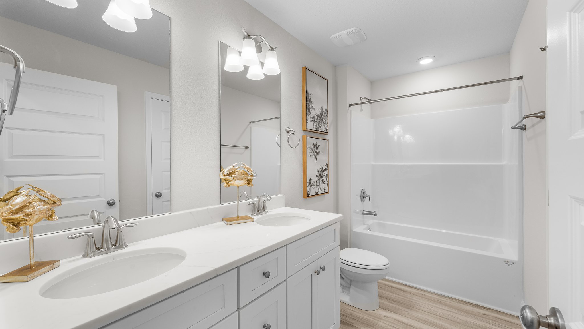 Bathroom with double vanity quartz countertops and toilet and shower.