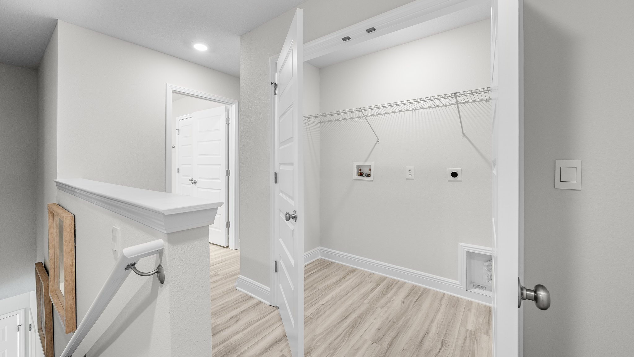 Upstairs laundry room in hallway with EVP flooring and ventilated shelving.