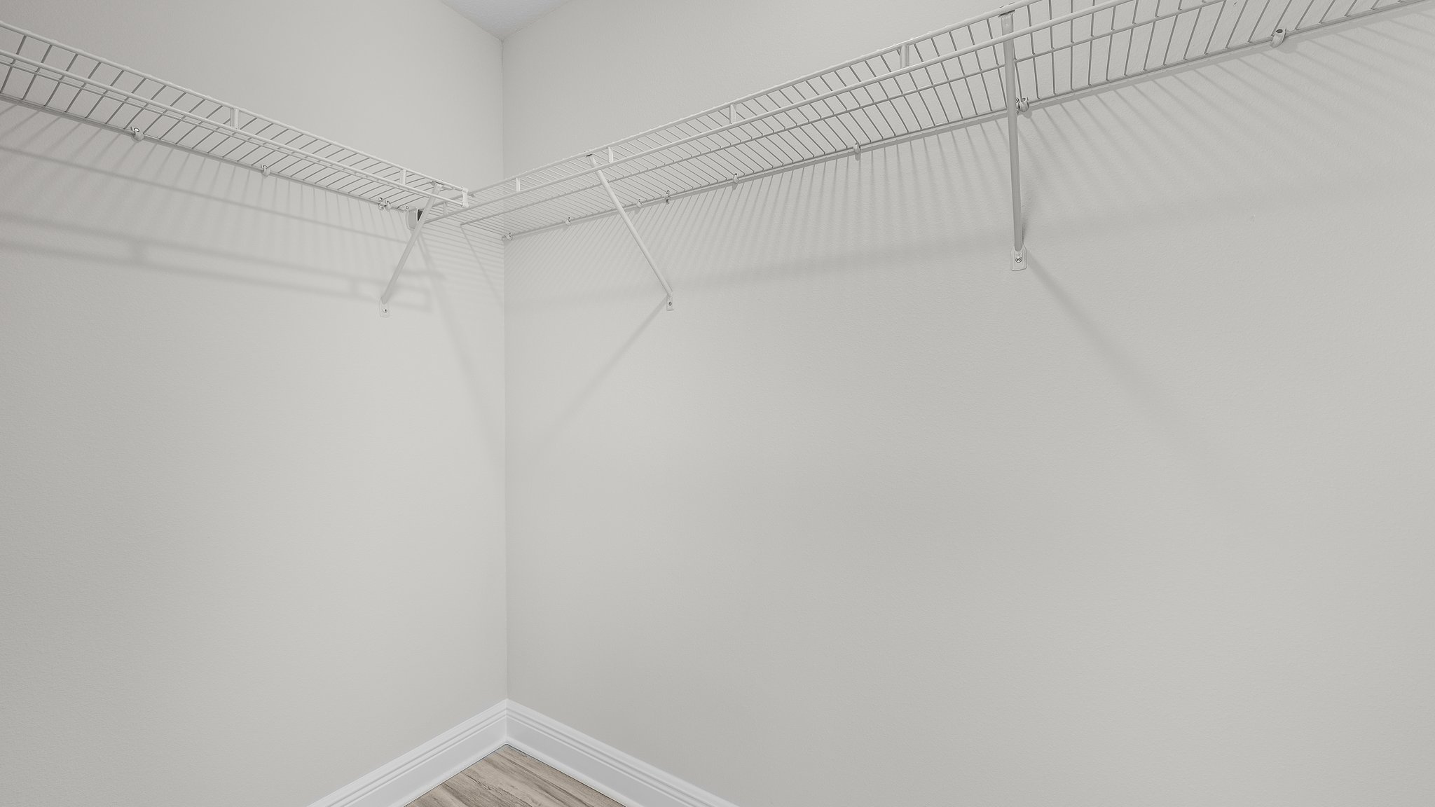 Primary bathroom closet with EVP flooring and ventilated shelving.