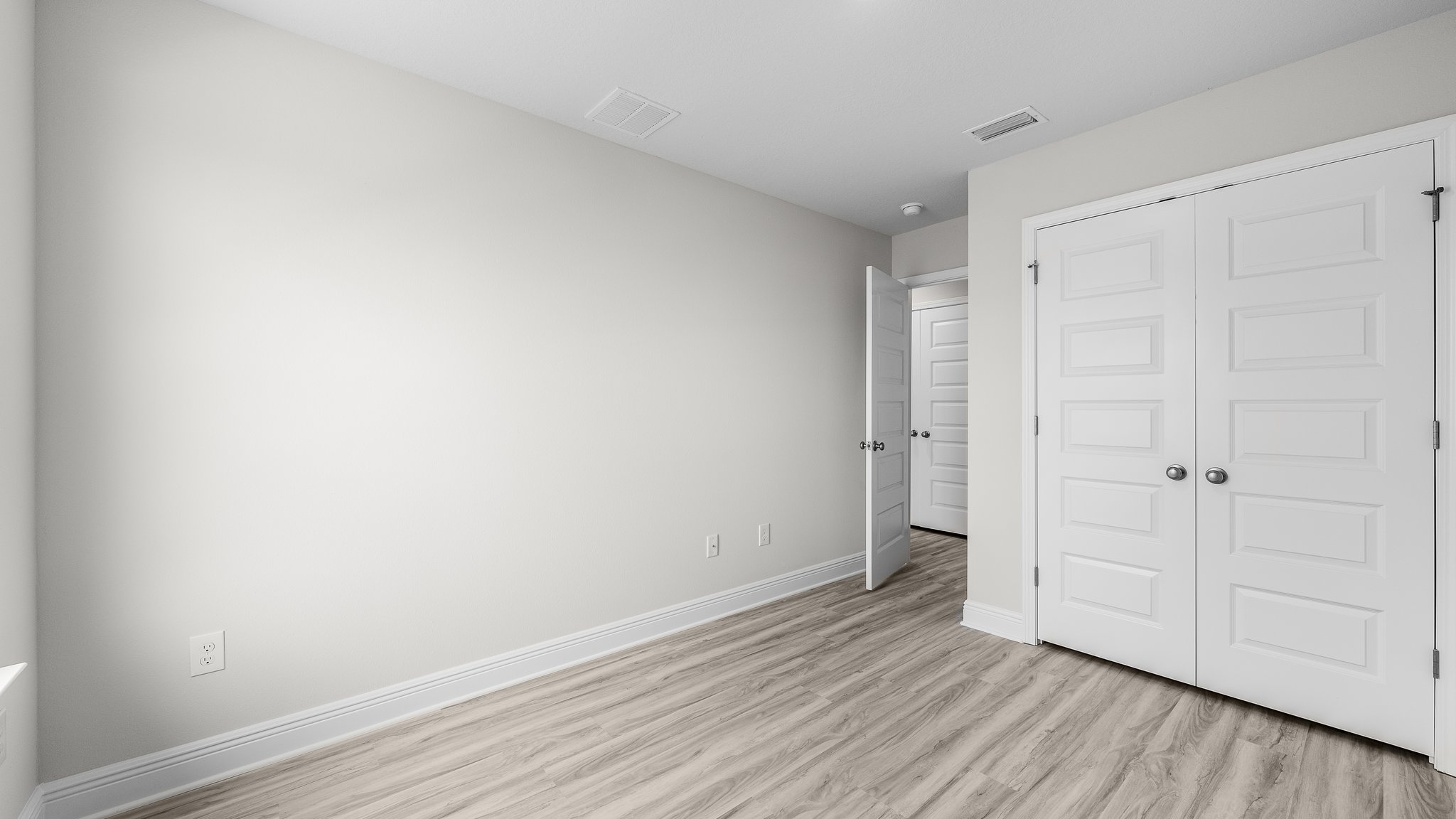 Bedroom with EVP flooring and closet.