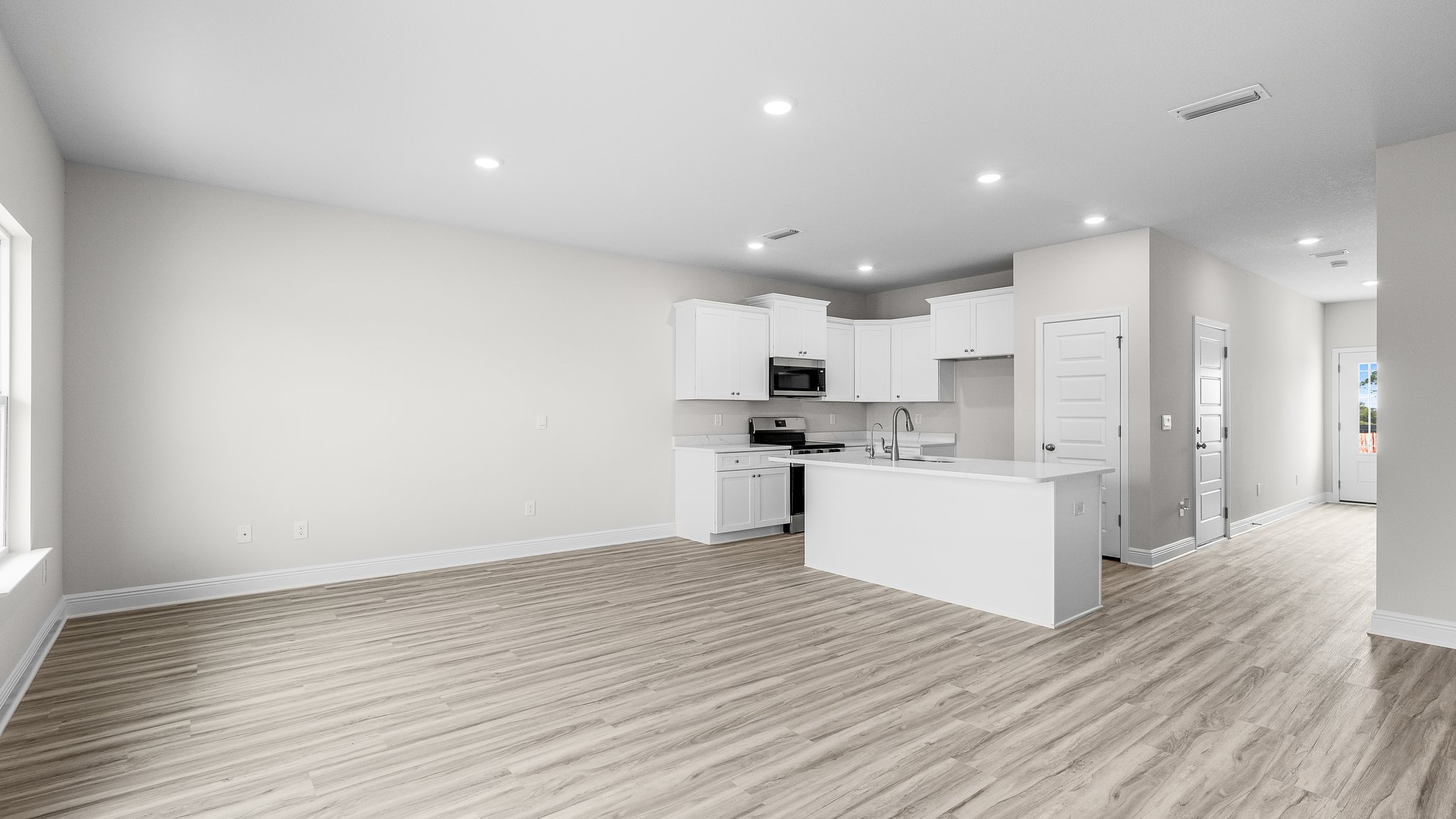 Open living room with EVP flooring and kitchen.