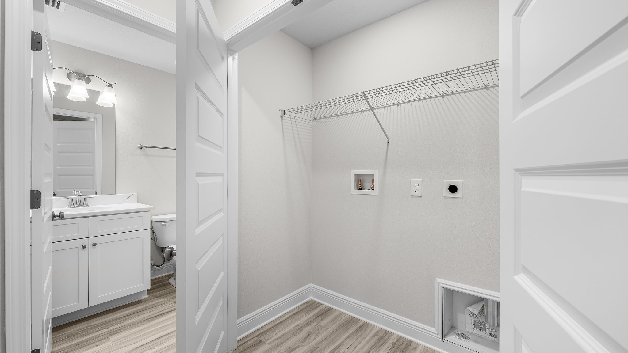 Upstairs laundry room with EVP flooring and ventilated shelving.